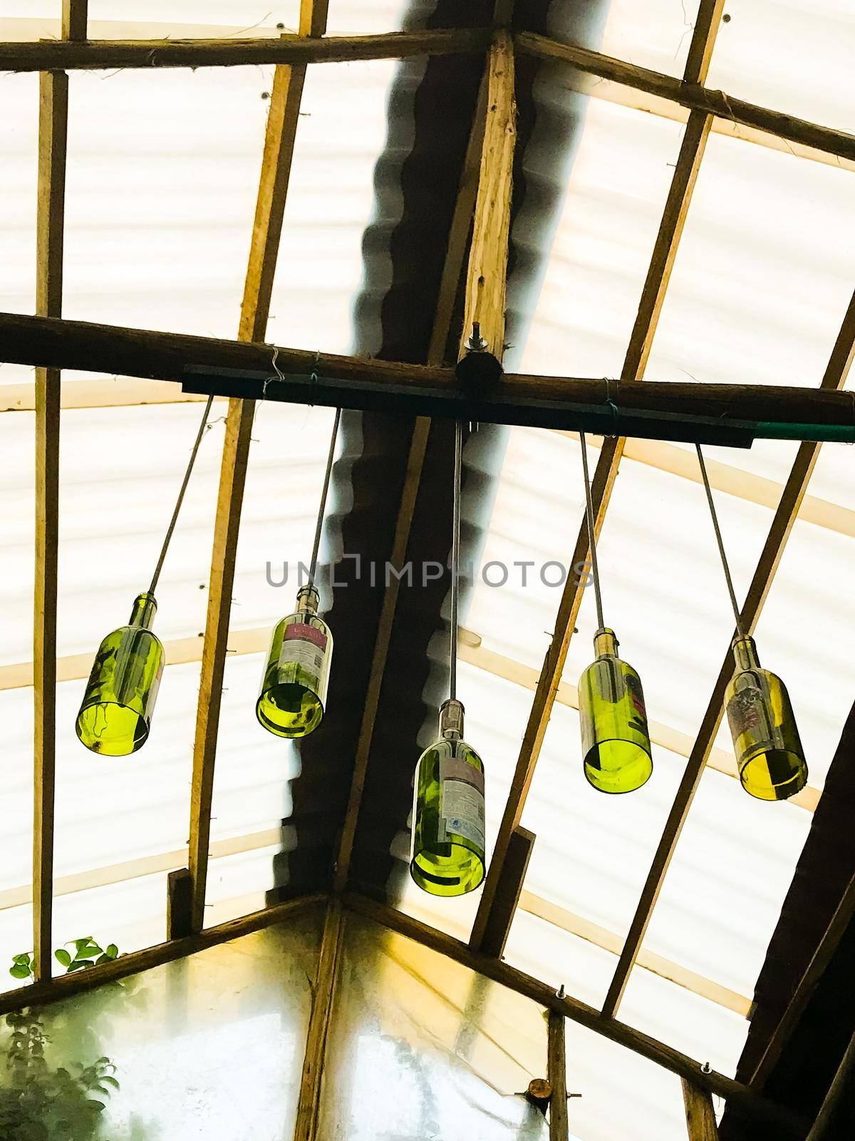 View from hammock at a cafe with hanging green bottle wind chimes by jyurinko