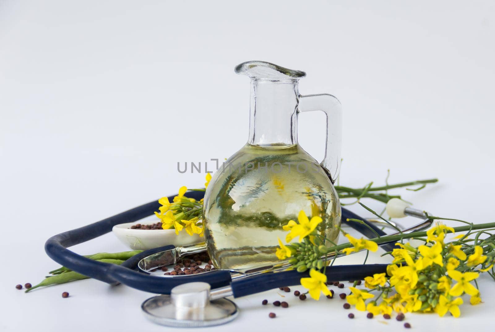 Health concept. Canola oil seeds and flowers with stethoscope, healthy