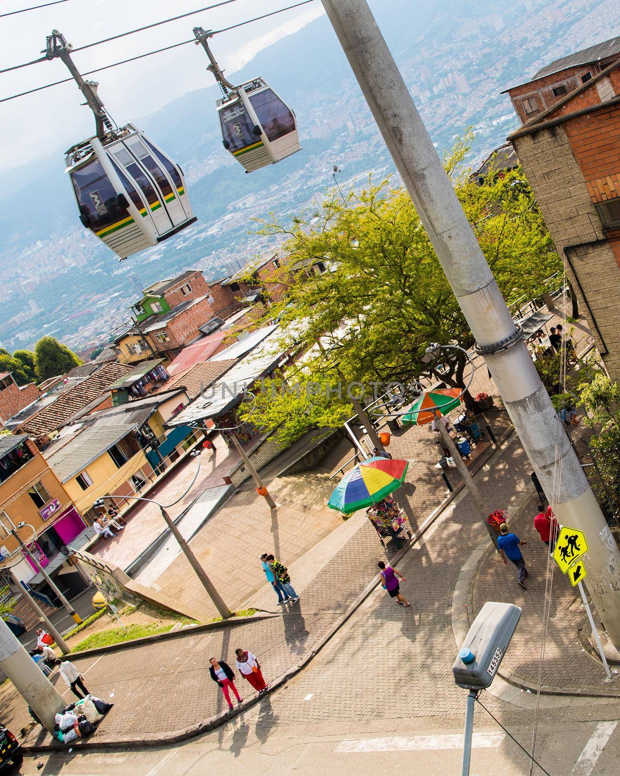 Cable cars in transit above houses in Medellin, Colombia. by jyurinko