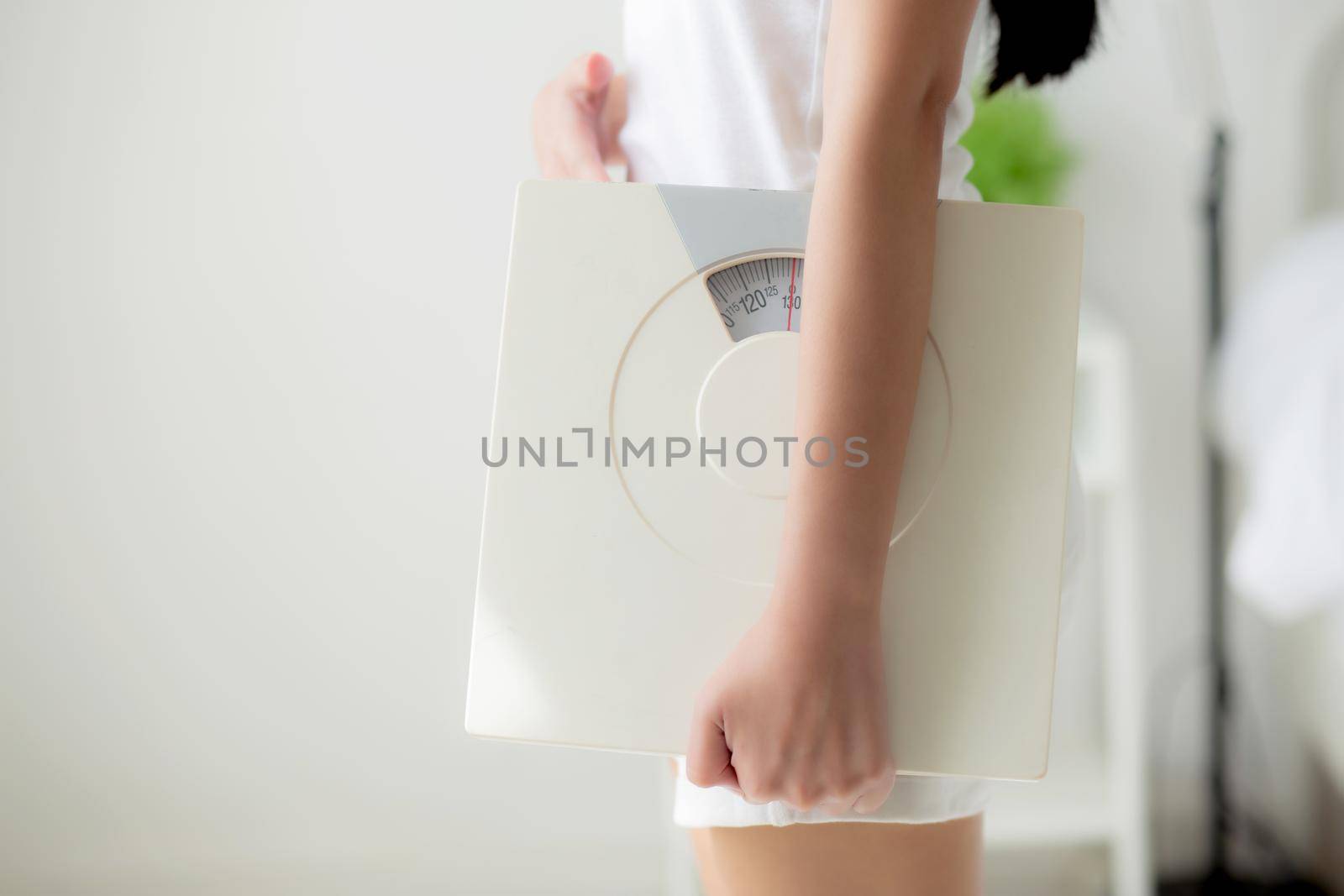 Closeup hands of woman holding scales with confident with control and weightloss of success, girl dieting for result of weight loss with satisfied, one person, healthy and lifestyles concepts.