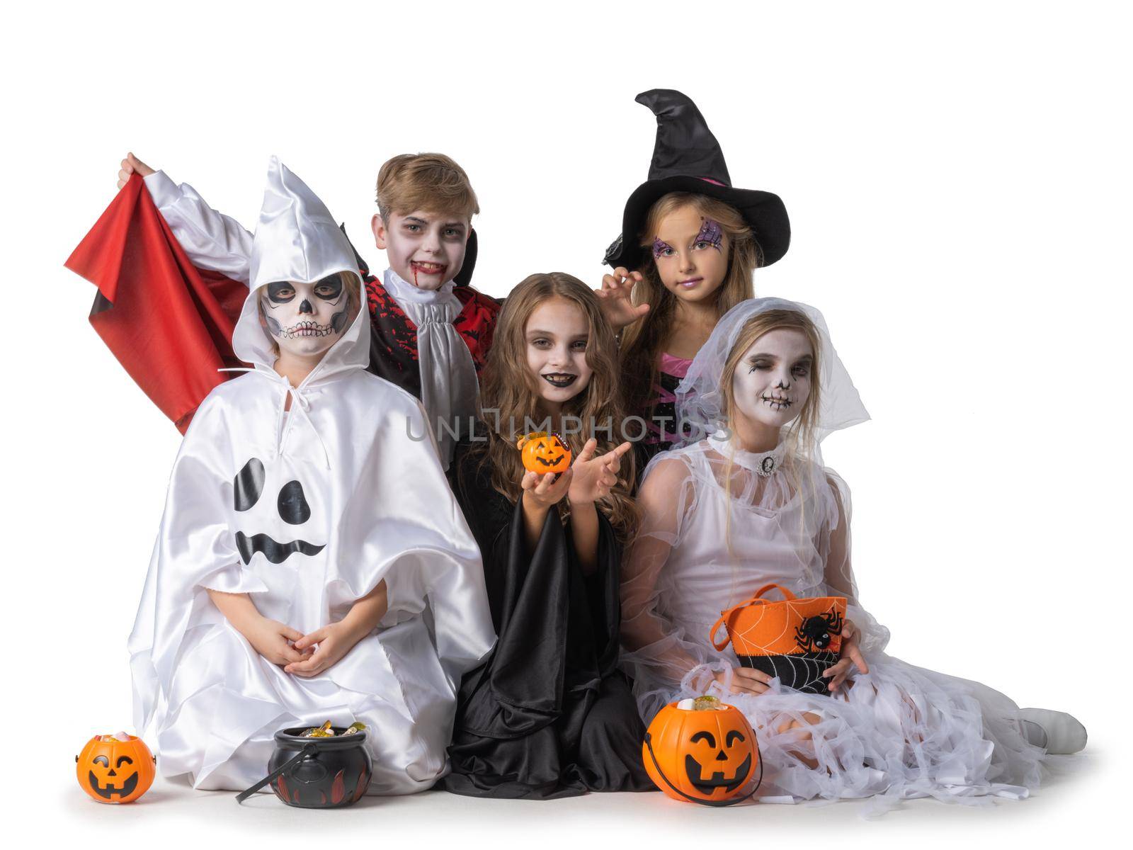 Group of children in fancy Halloween costume dress isolated on white background, going trick or treating with buckets of candies