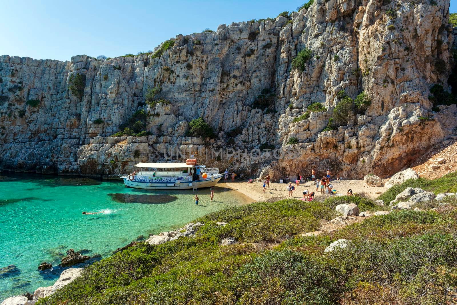 People swimming in the clear blue waters of Proti Island, near Marathopoli, Messinia at Peloponnese. by ankarb