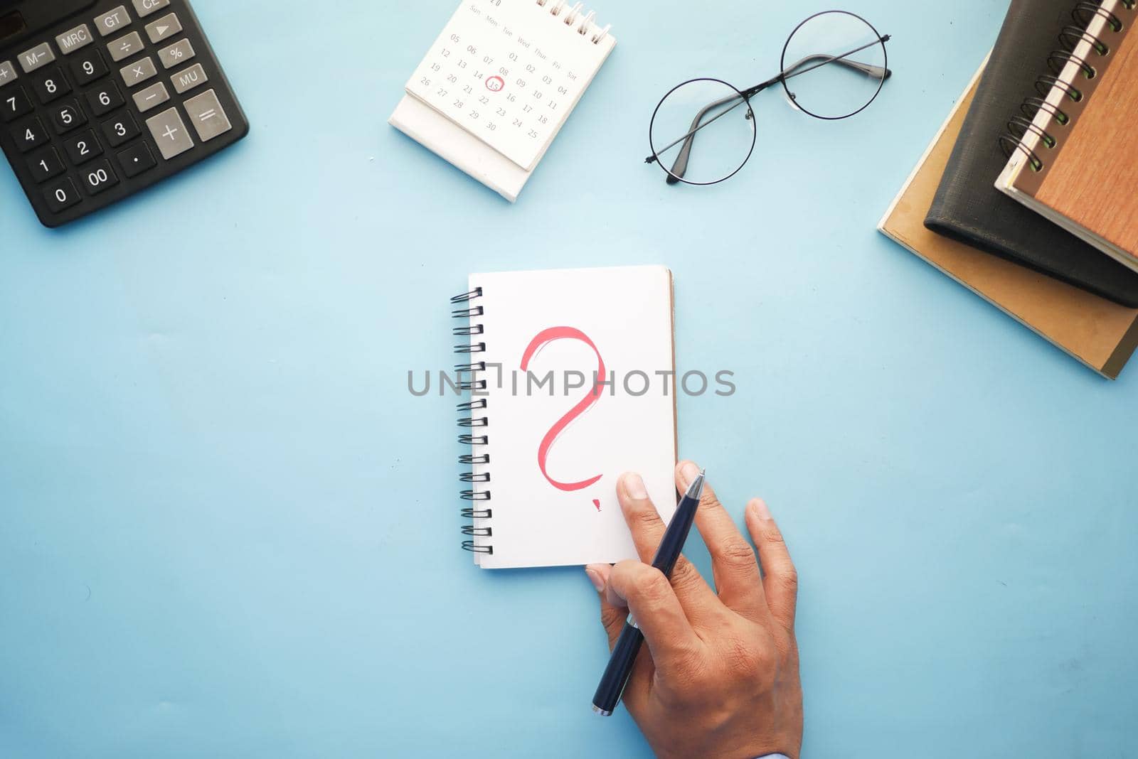 high angle view of question mark on paper on office desk.