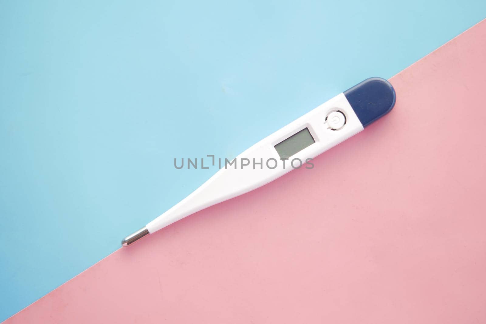 medical thermometer on pink background with copy space.