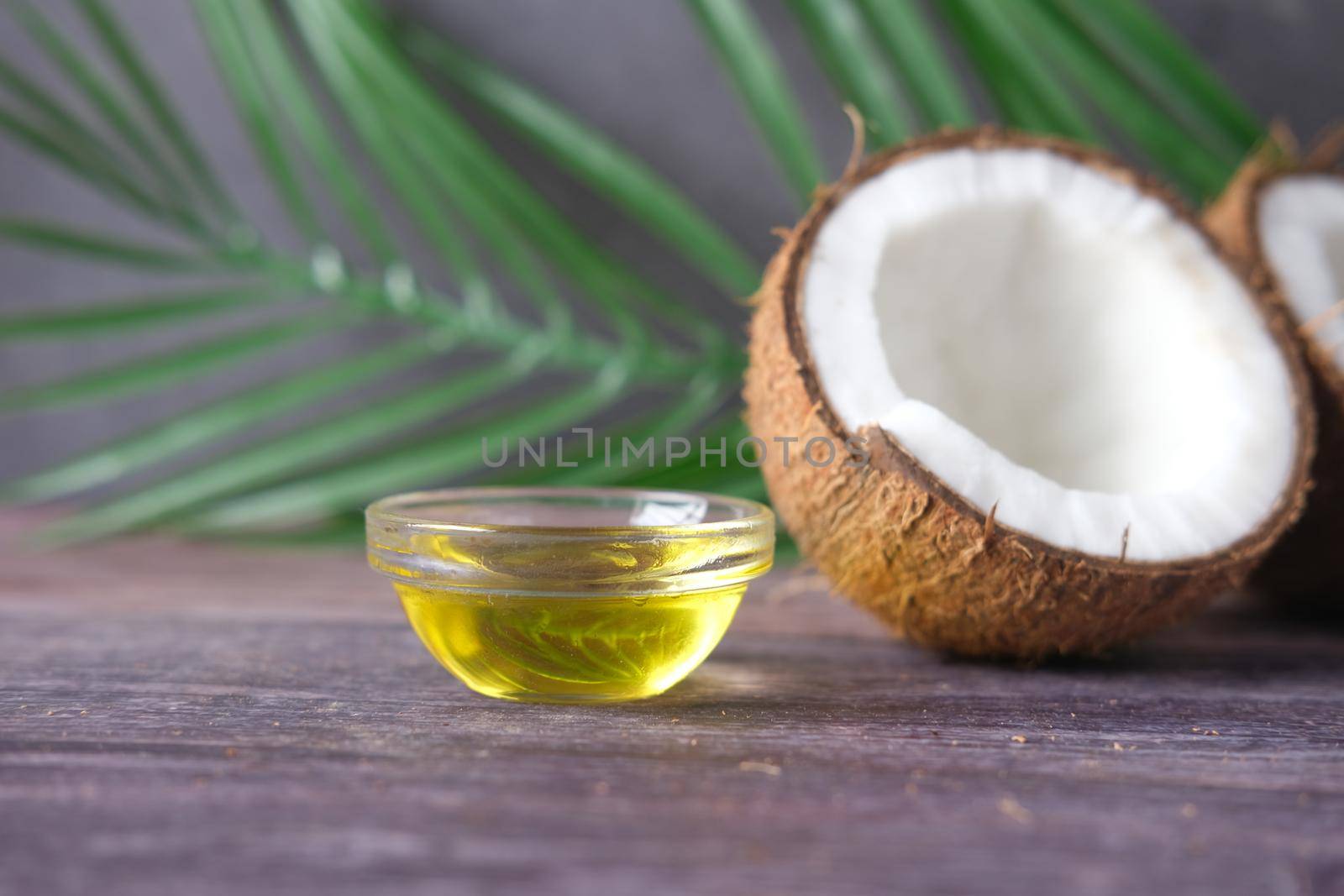 slice of fresh coconut and bottle of oil on a table by towfiq007