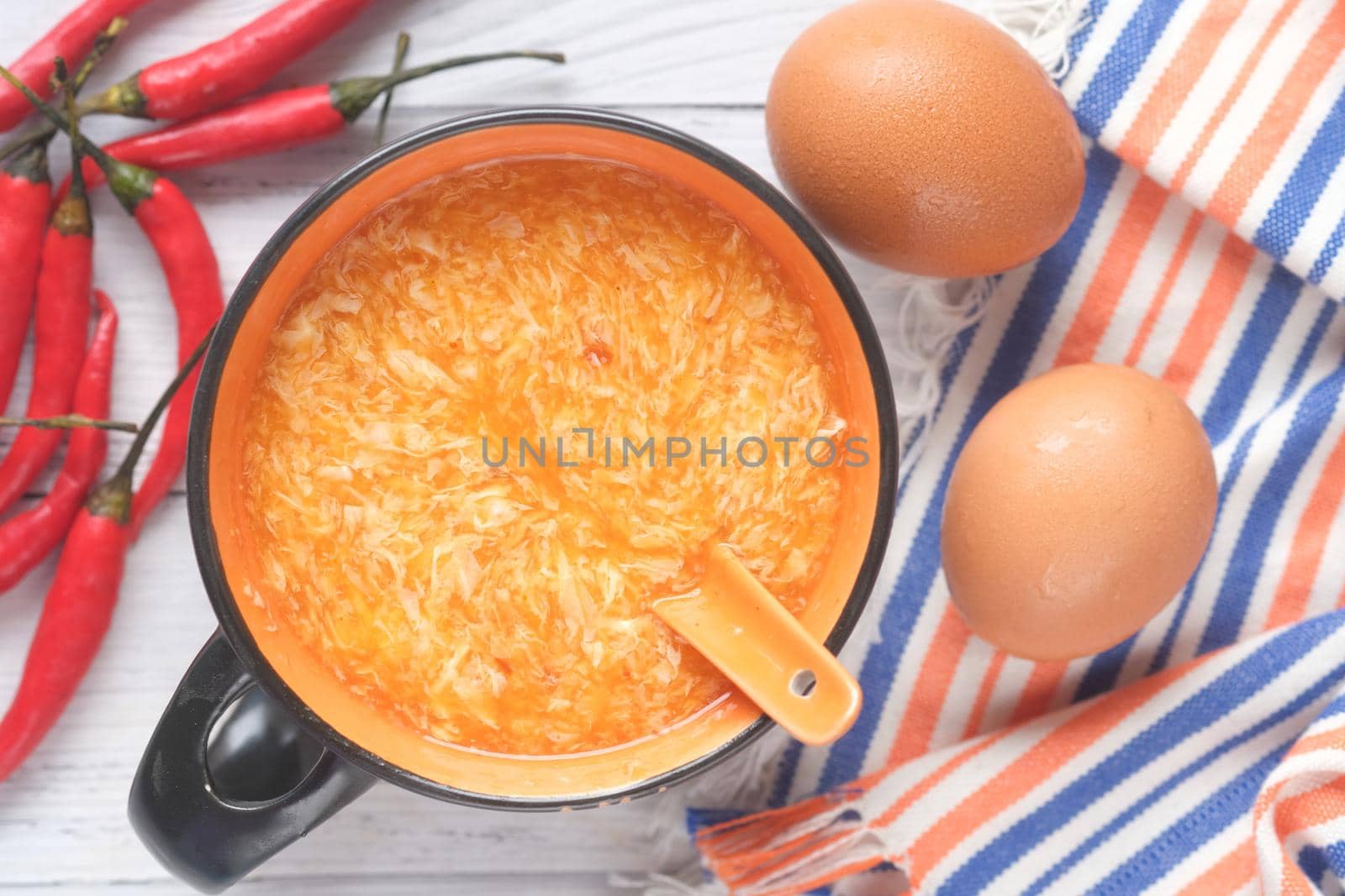Traditional chinese egg drop soup with chili and egg on table