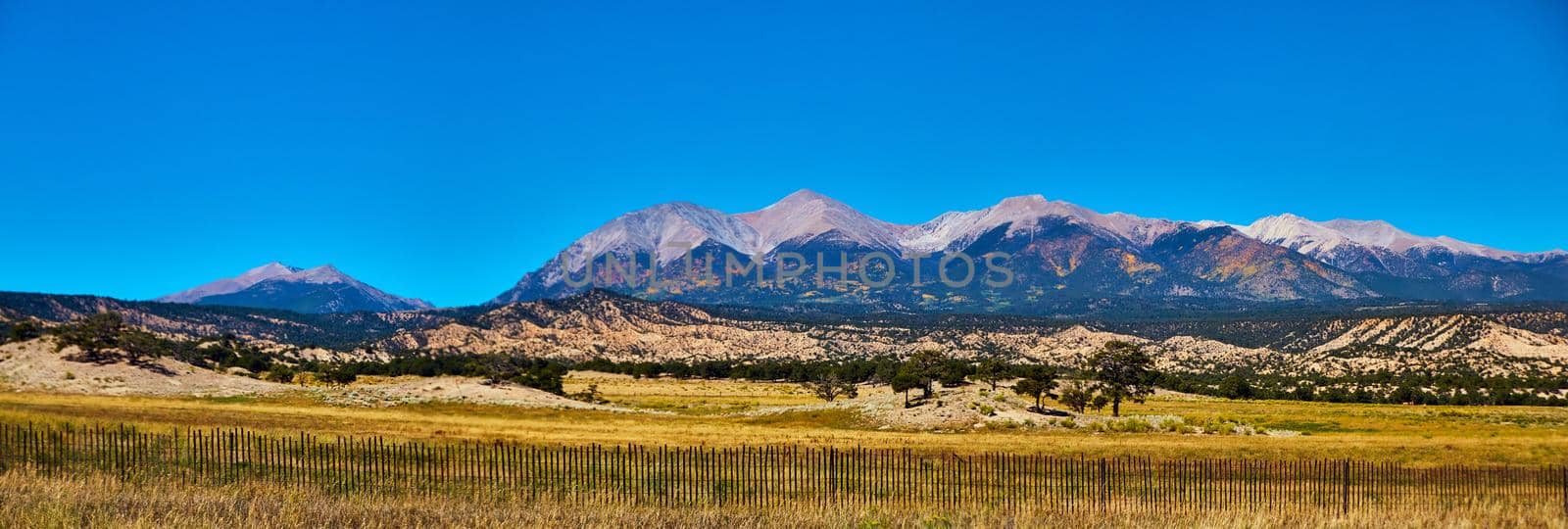 Panorama of midwest mountain range in desert with simple wood fence in foreground by njproductions