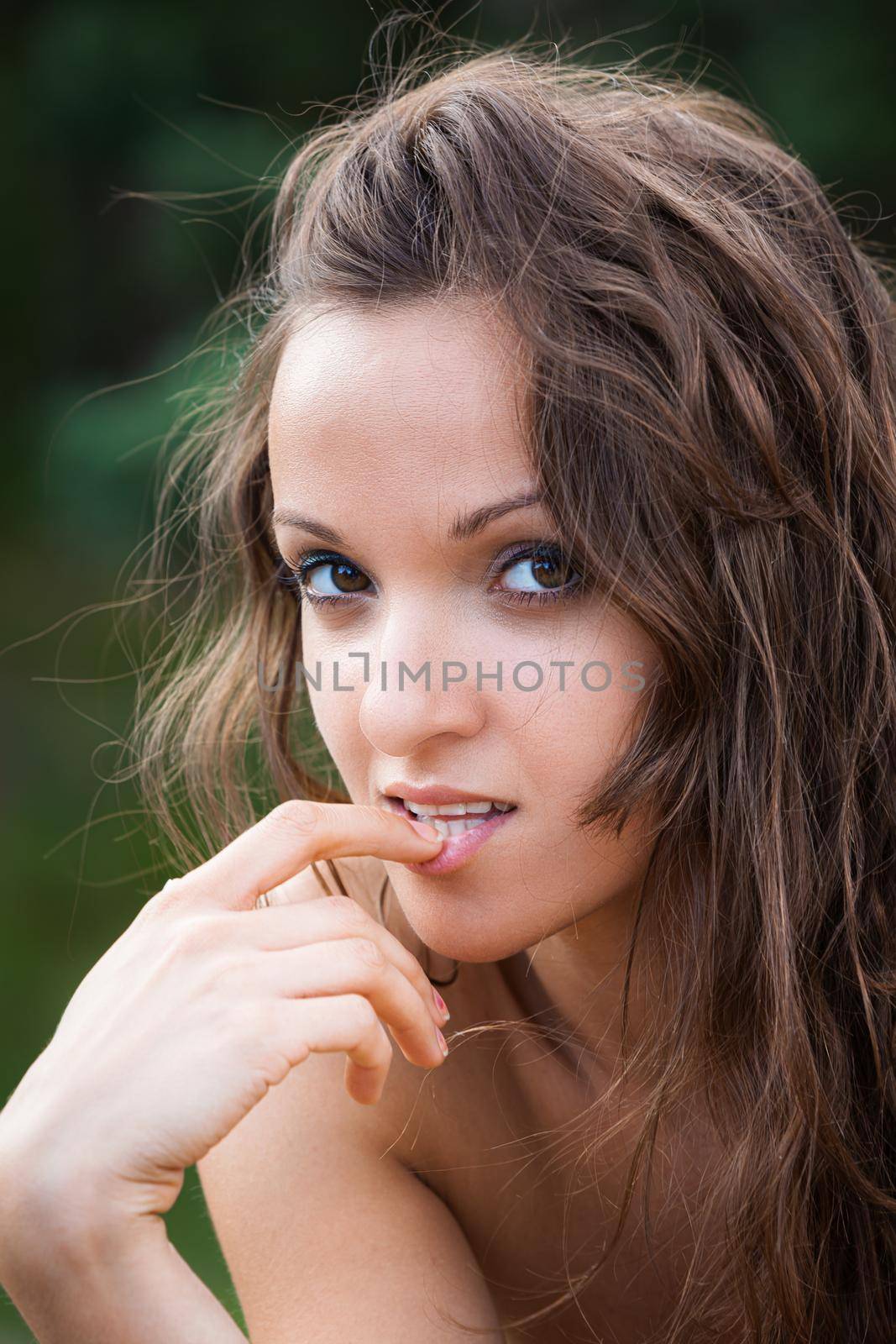 Portrait of emotional half-naked young woman on natural background