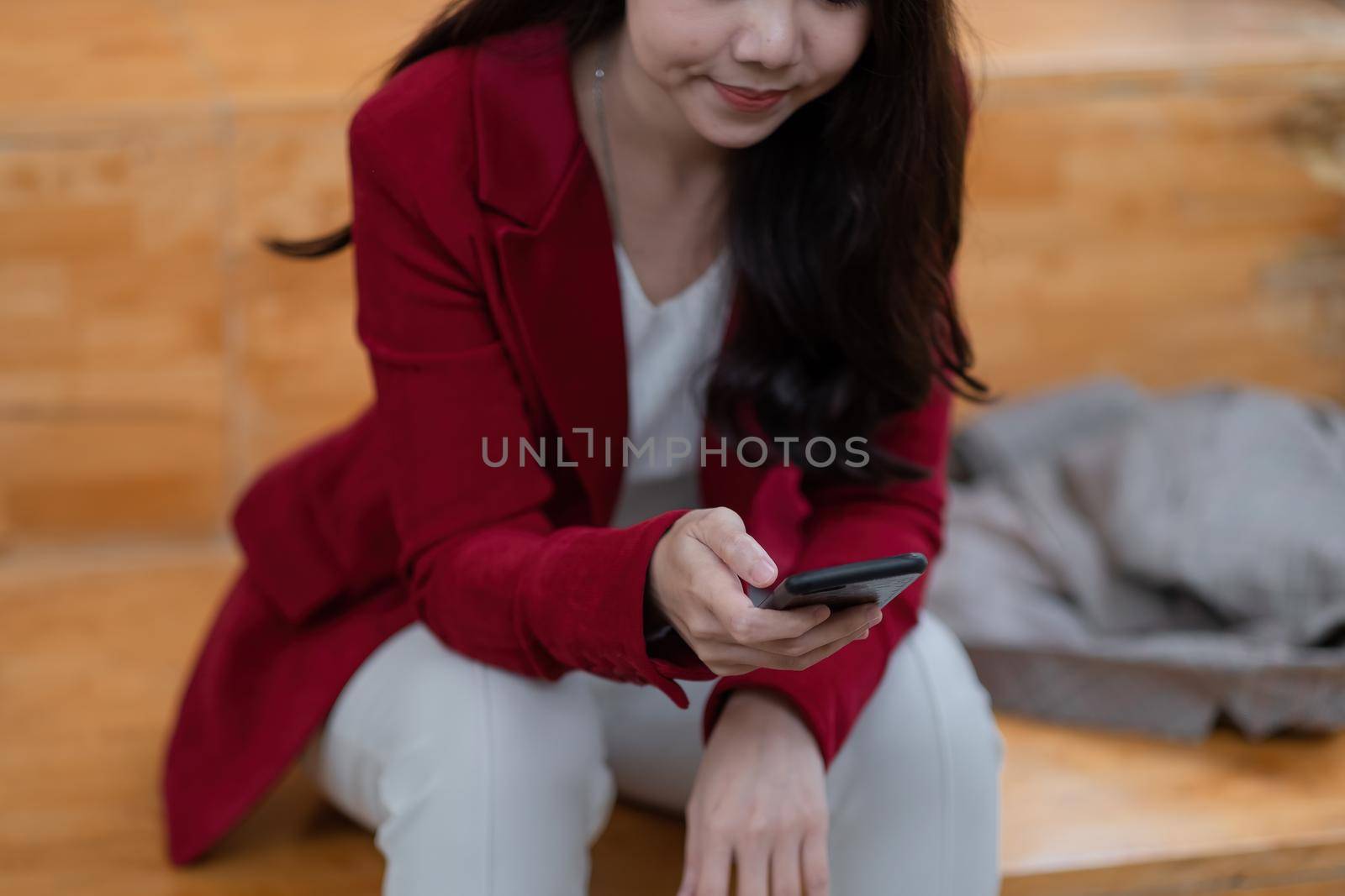 Cropped shot of asian woman using smart phone at home. messaging or browsing social networks.