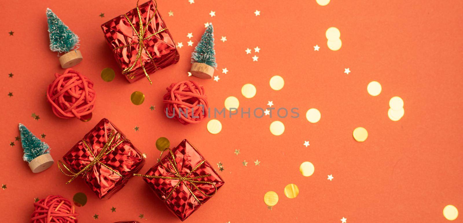 Red Christmas gifts and Christmas trees on a red background. An article about the New year and Christmas. The choice of gifts. A red gift . New Year's background