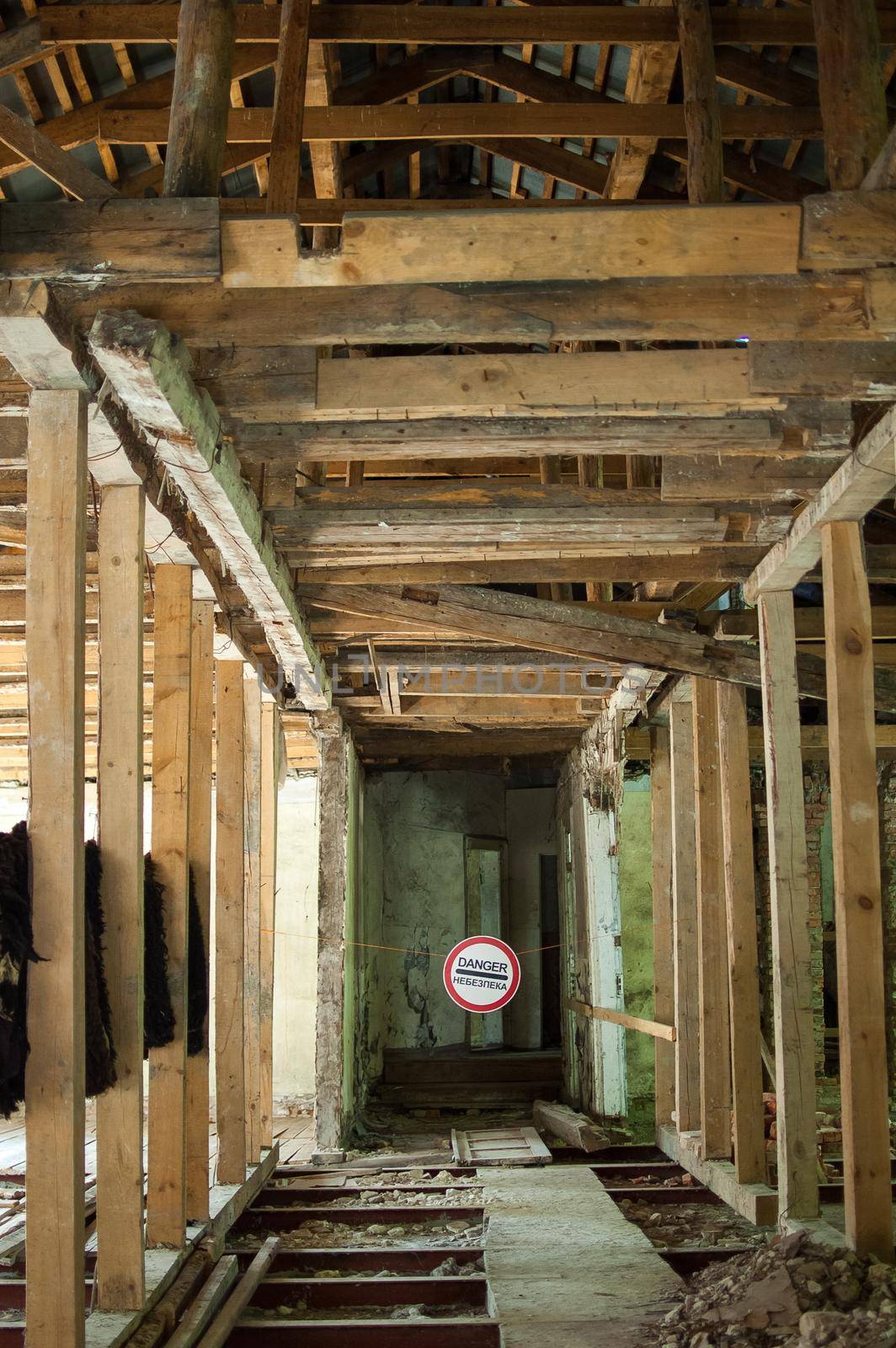 Old wrecked house with 'Danger' in English and in Ukrainian warning sign, abandoned building, uninhabitable place by balinska_lv