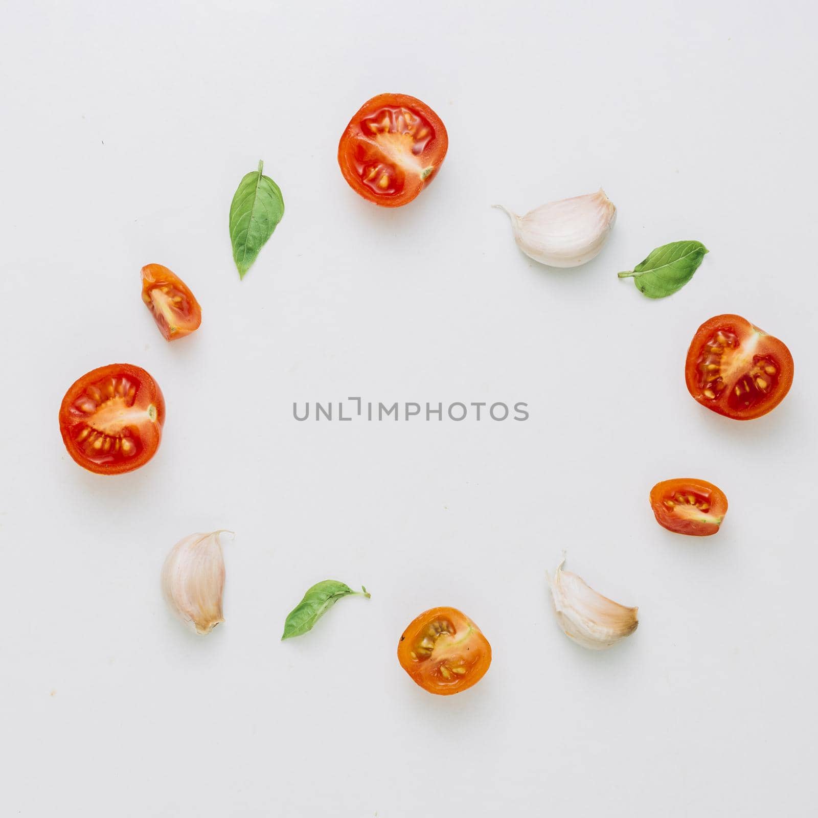 circular frame made with cherry tomatoes basil garlic cloves white background. Resolution and high quality beautiful photo