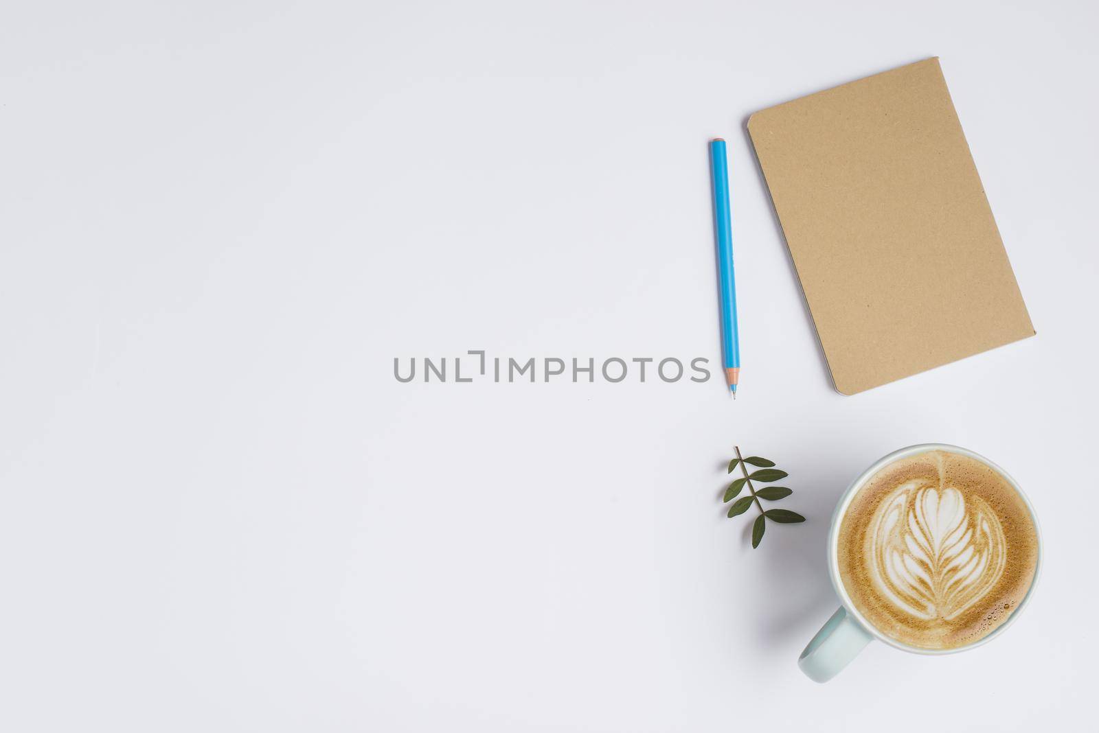 closed notebook colored pencil leaves cup coffee with latte art white background. Resolution and high quality beautiful photo