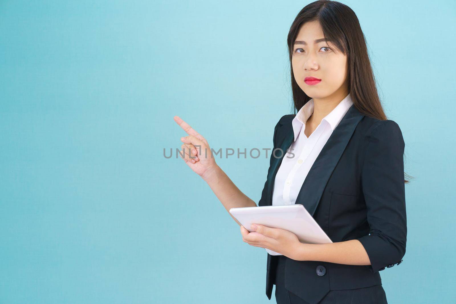 Young Asain women long hair in suit standing using her digital tablet computer  and pointing finger