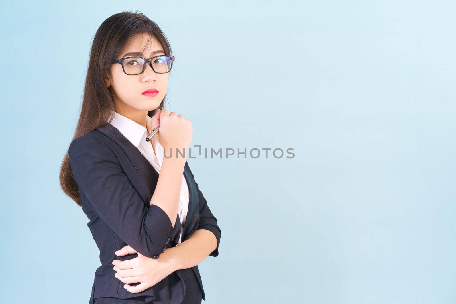 Young asian girl wearing suit with support hand on chin by stoonn