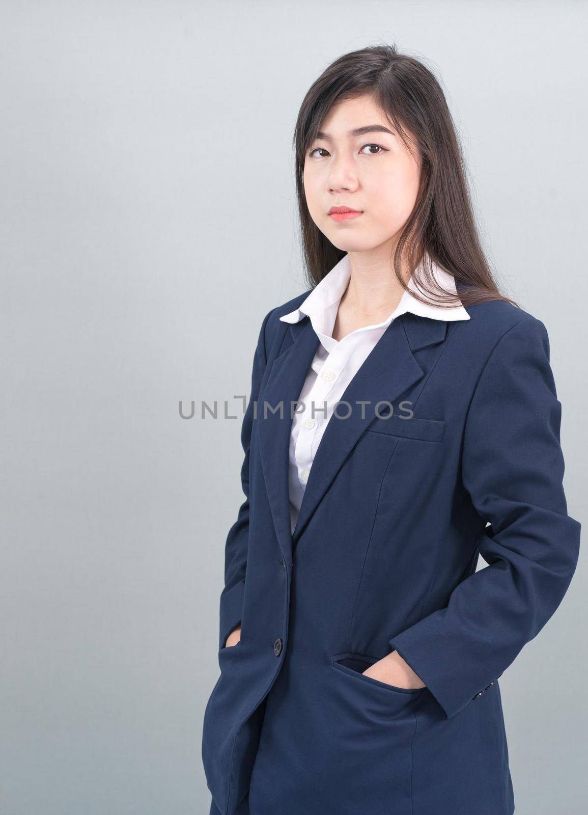 Portrait of asian business woman standing isolated on gray background