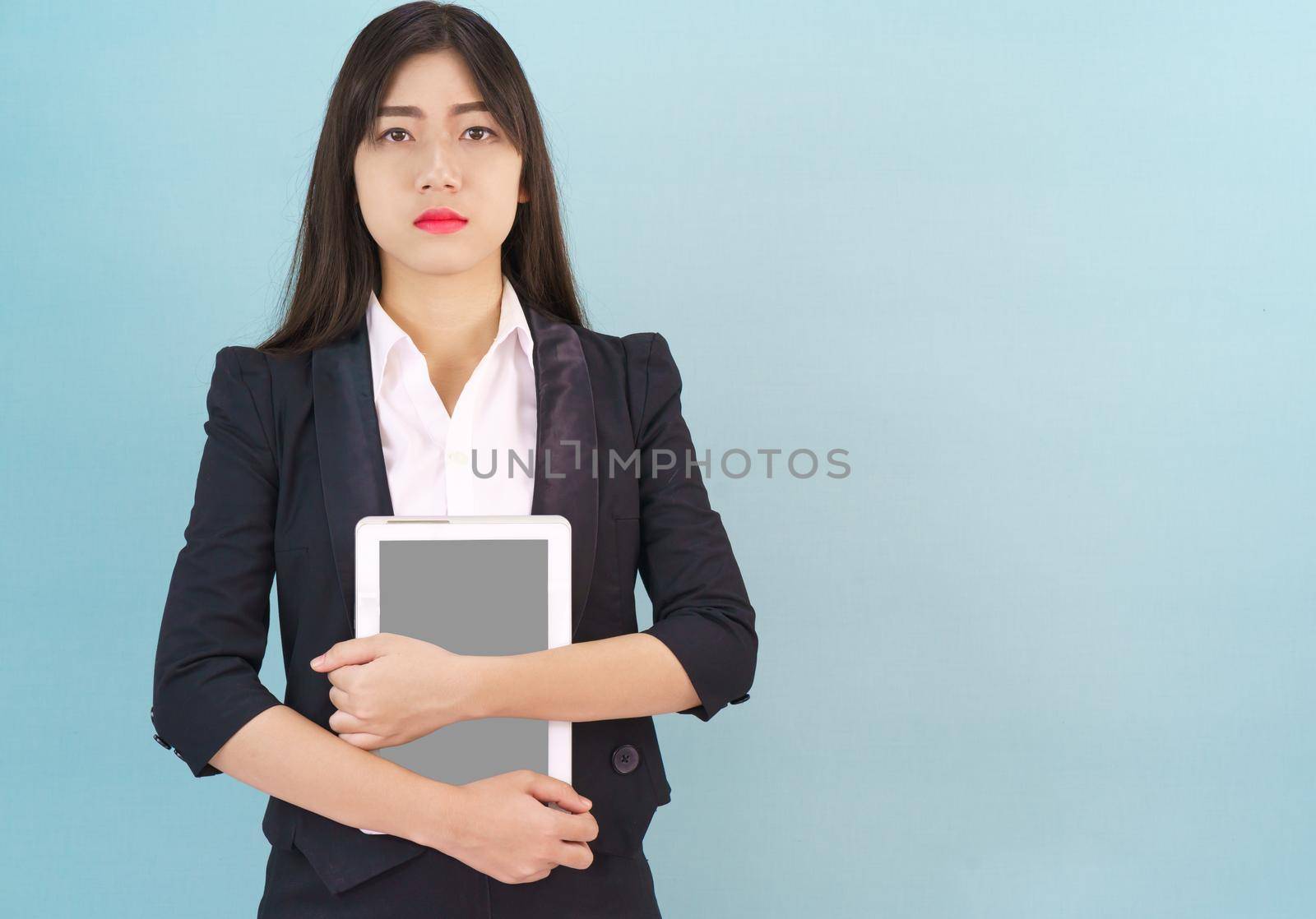 Young women standing in suit holding digital tablet by stoonn
