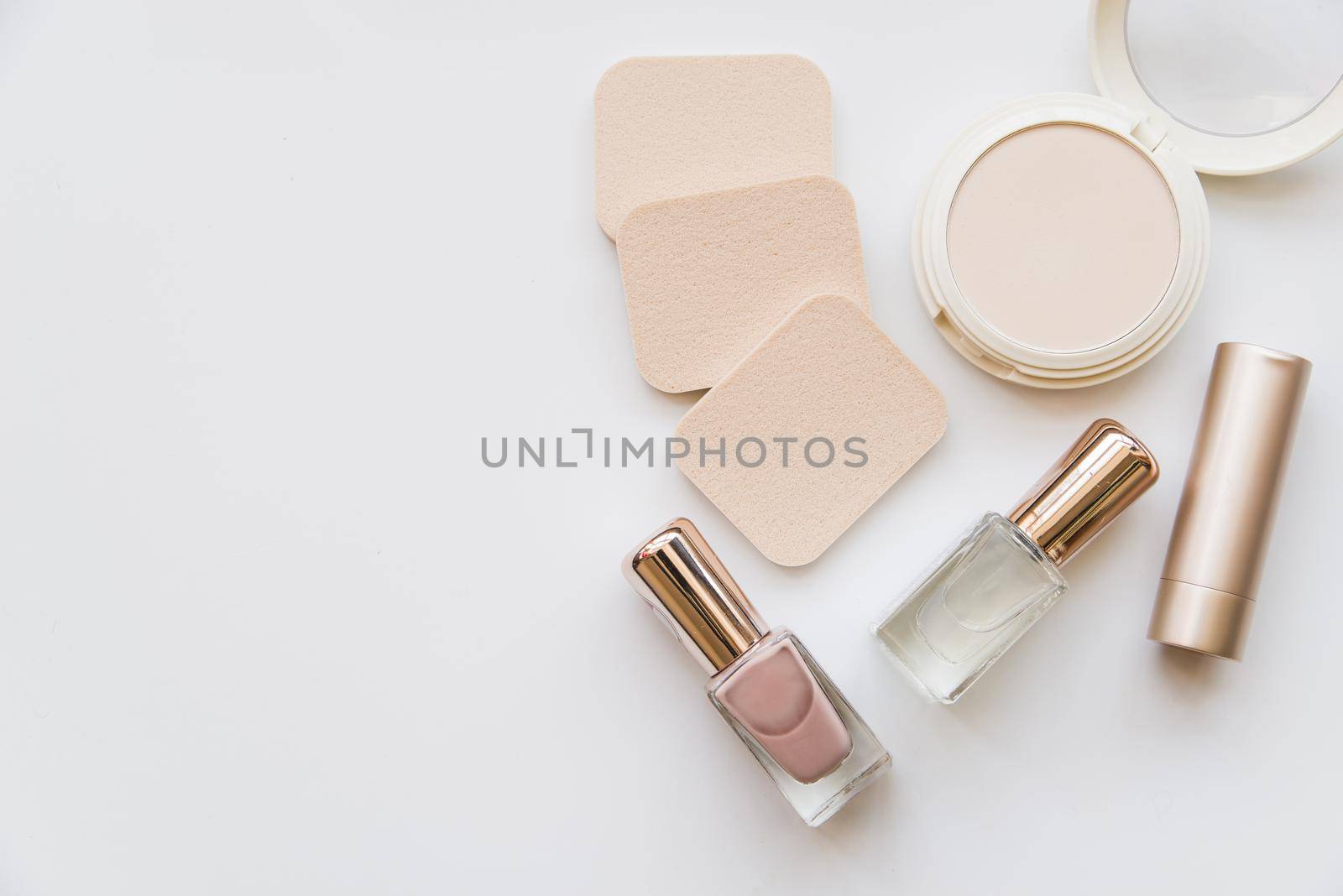 overhead view nail polish bottle lipstick sponge compact white background. Resolution and high quality beautiful photo