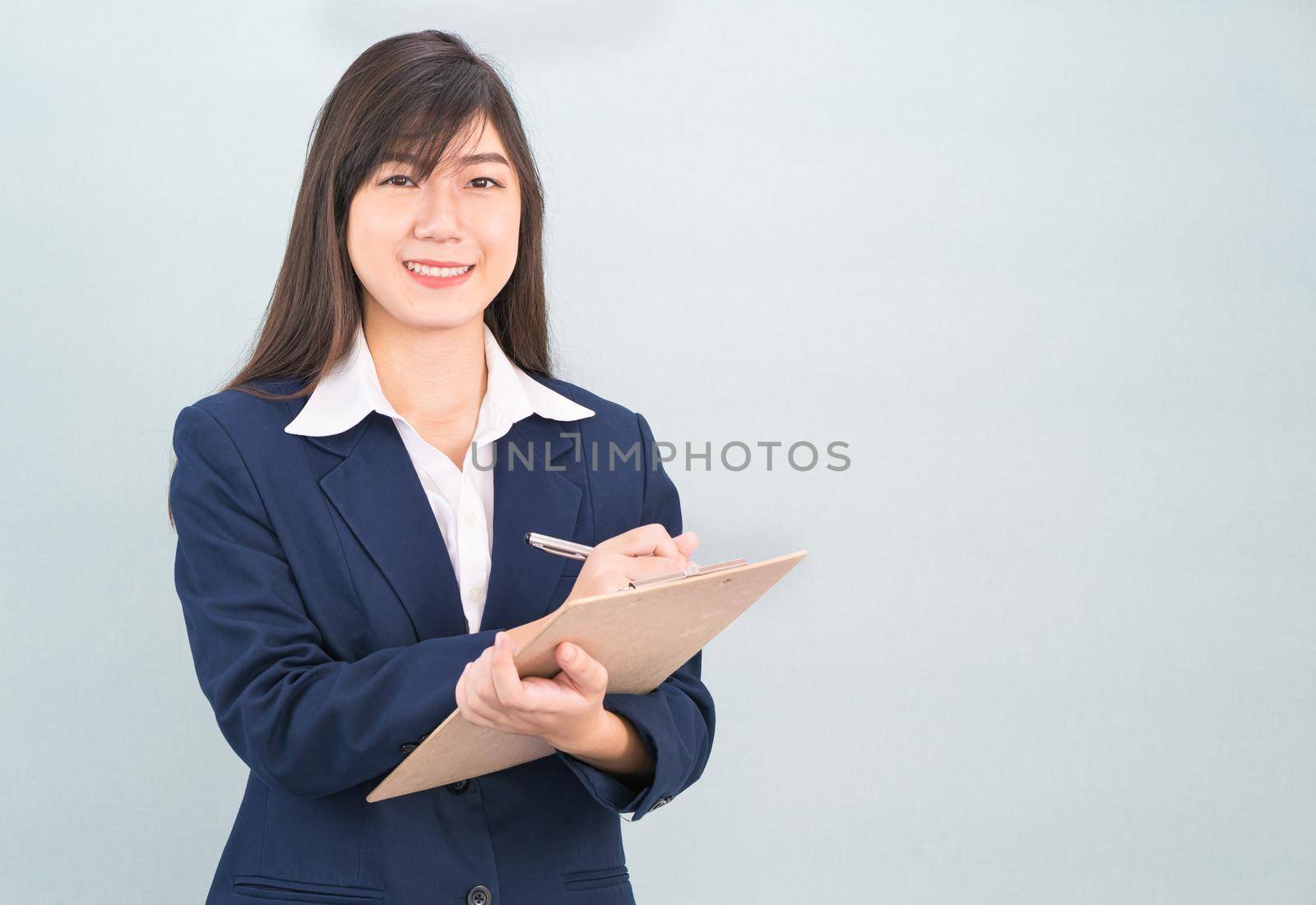 Asian woman long hair and wearing suit  with clipboard and pen in hands by stoonn