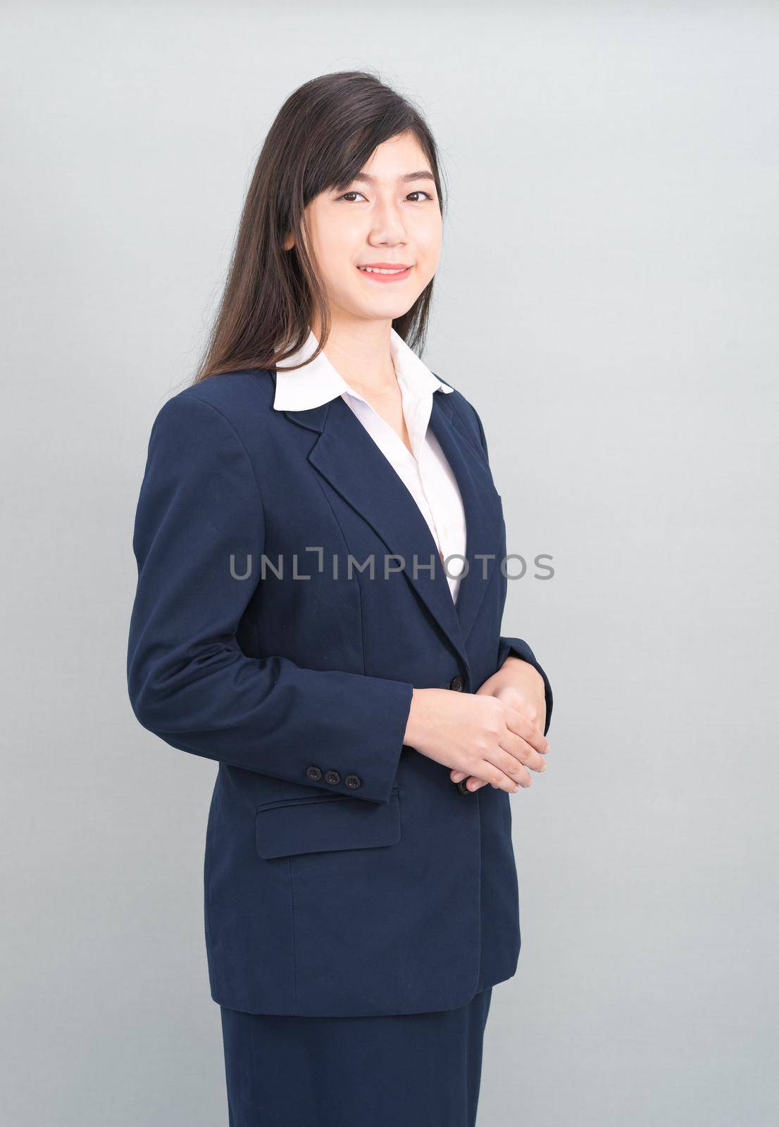 Portrait of asian business woman standing isolated on gray background