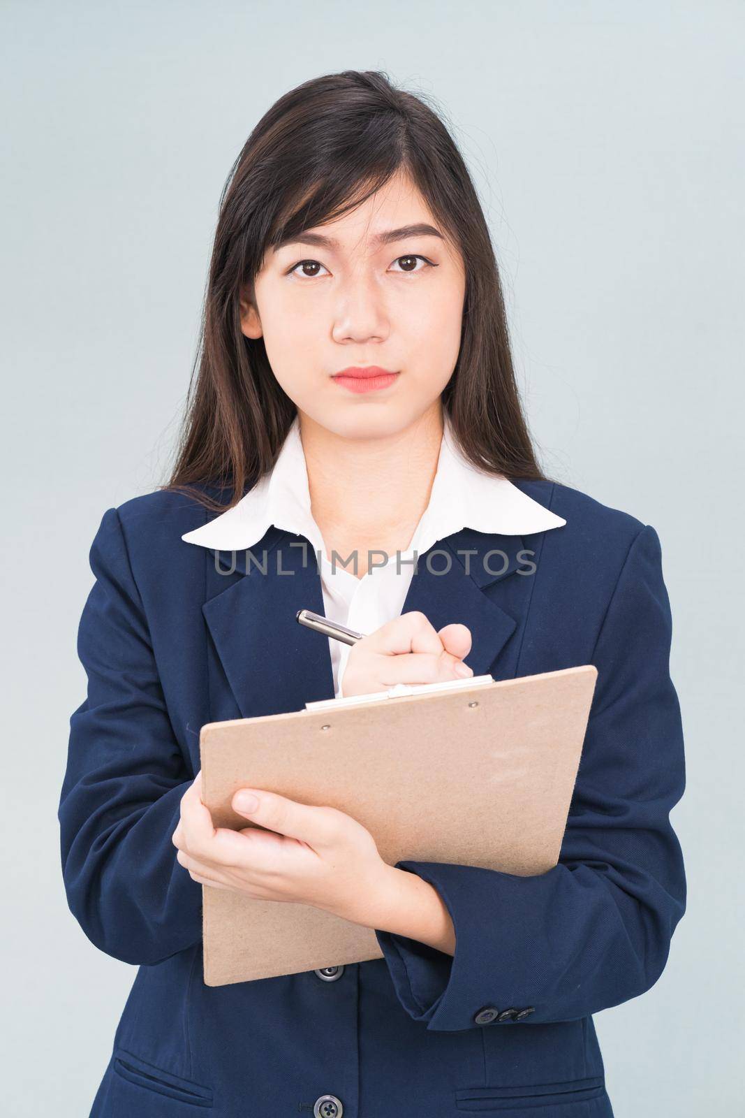 Portrait of Asian woman long hair and wearing suit  with clipboard and pen in hands thinking about success, isolated on white background