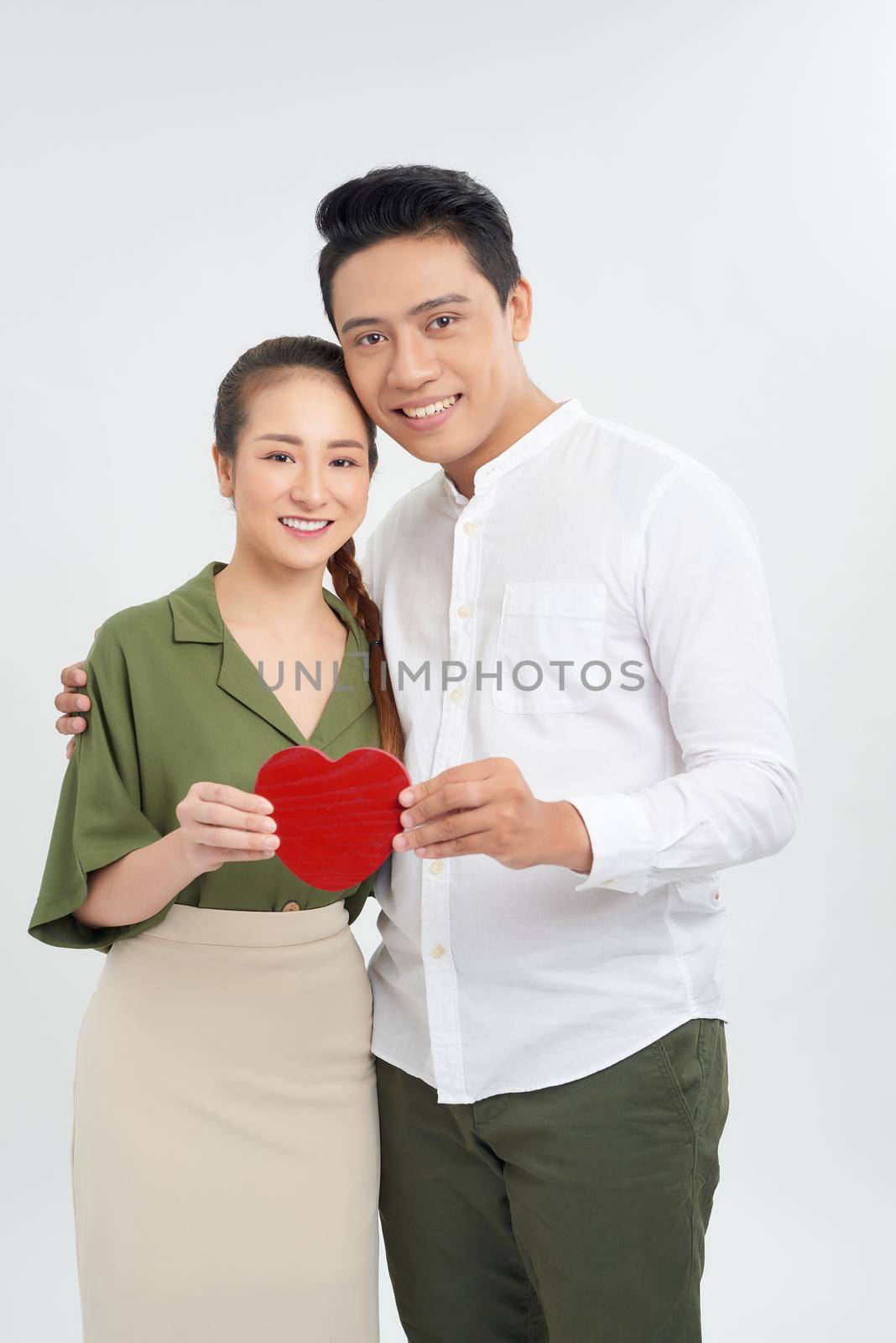 young love couple holding red heart, happy smile embrace, isolated over white background, valentine day concept by makidotvn