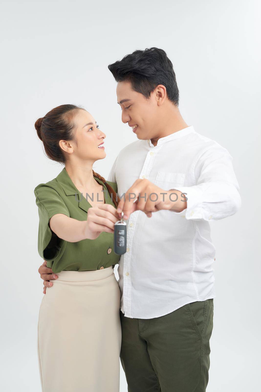 Good looking young couple holding the keys for a brand new car they just bought together by makidotvn