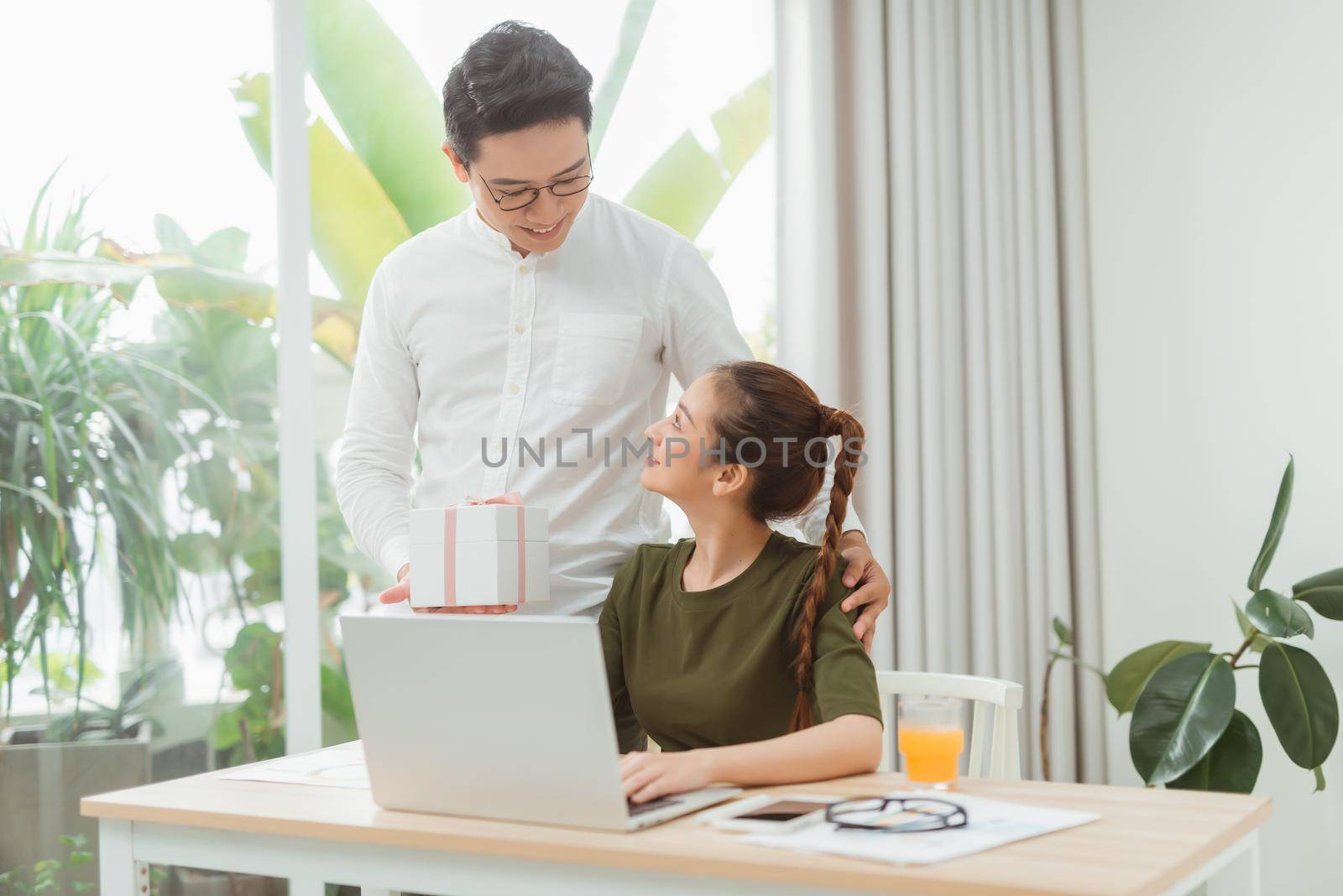 Young asian men presenting gift to glad girl