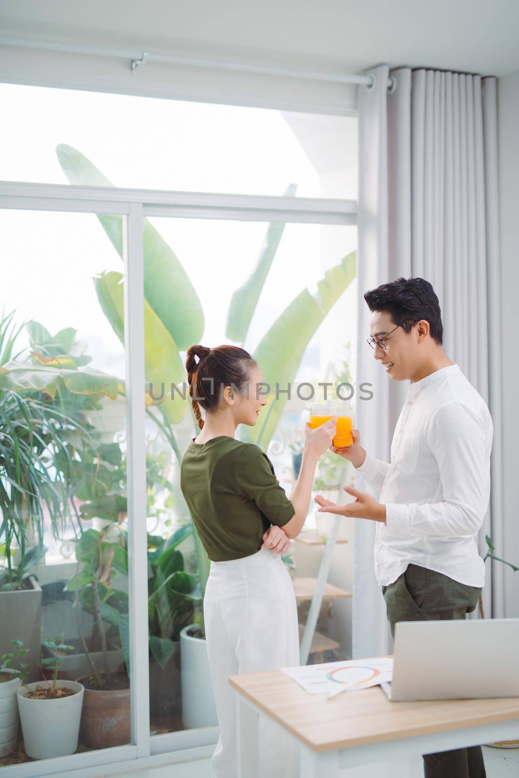 Beautiful young couple in office, using laptop