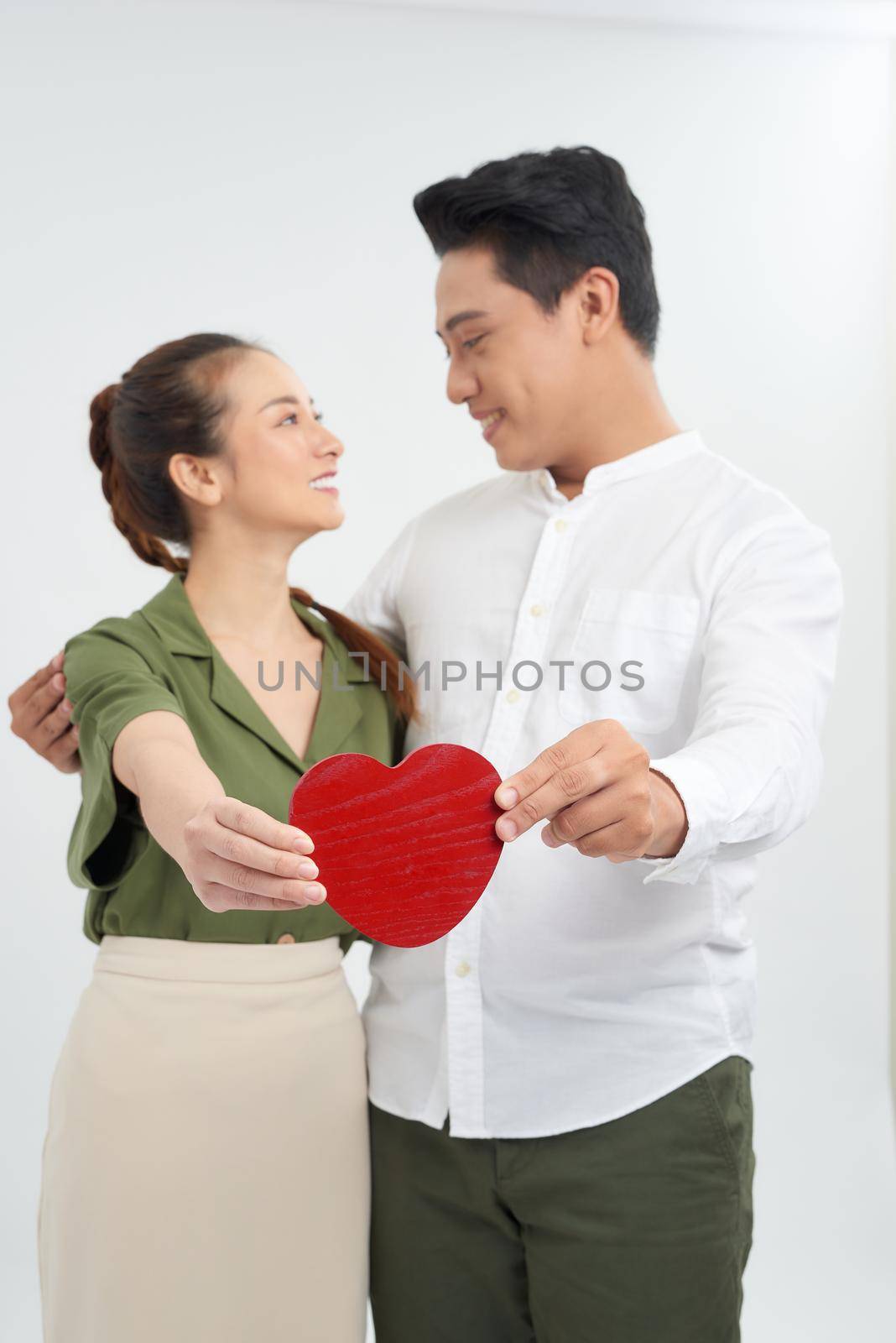 young love couple holding red heart, happy smile embrace, isolated over white background, valentine day concept