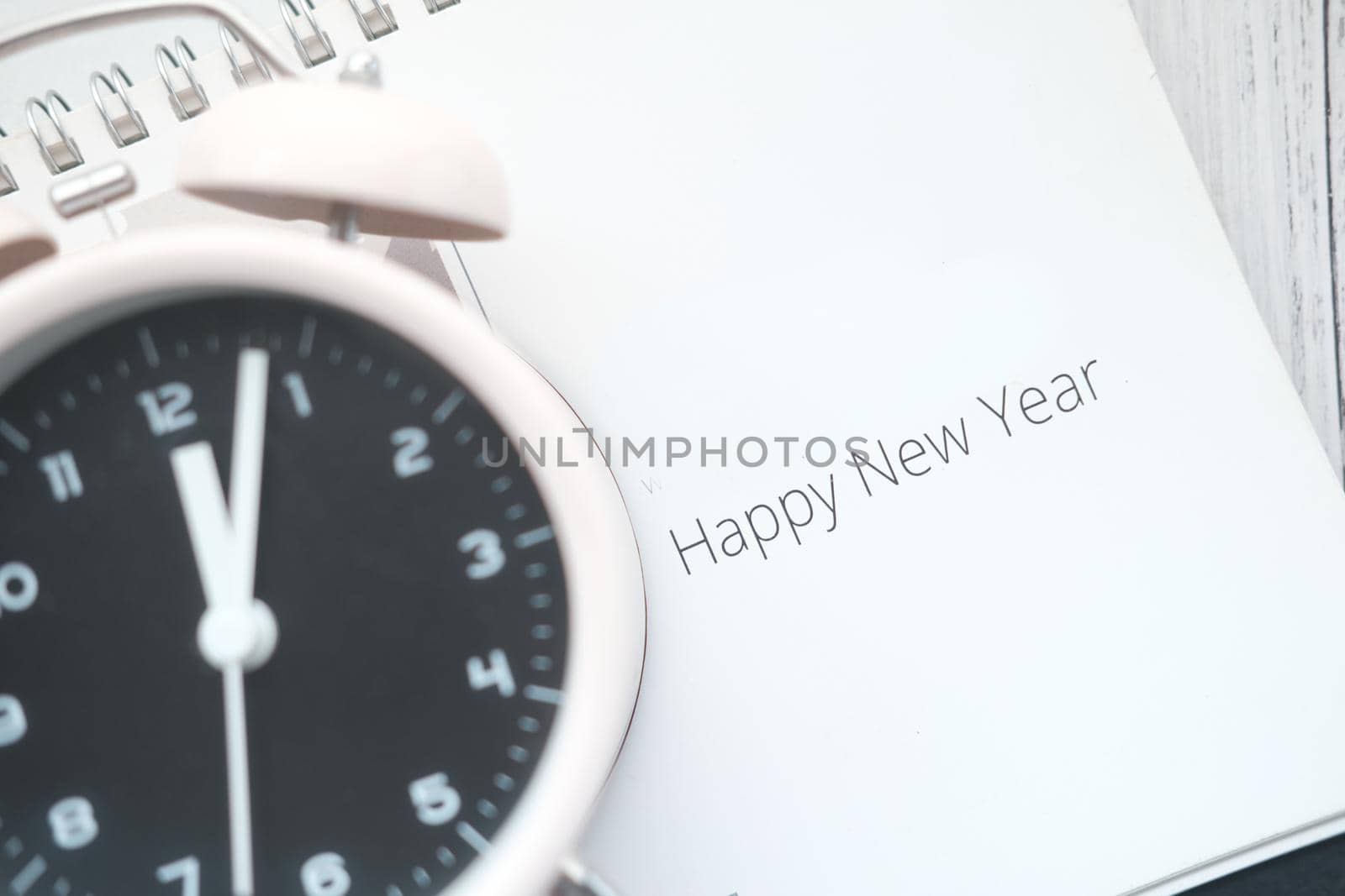 happy new year text on calendar with clock on table by towfiq007