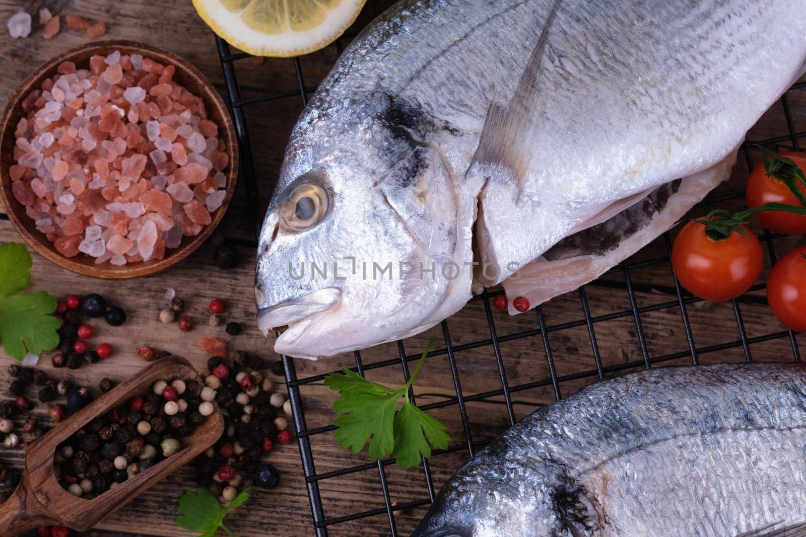 Raw dorado with spices ready to cook on a wooden background. by Fischeron