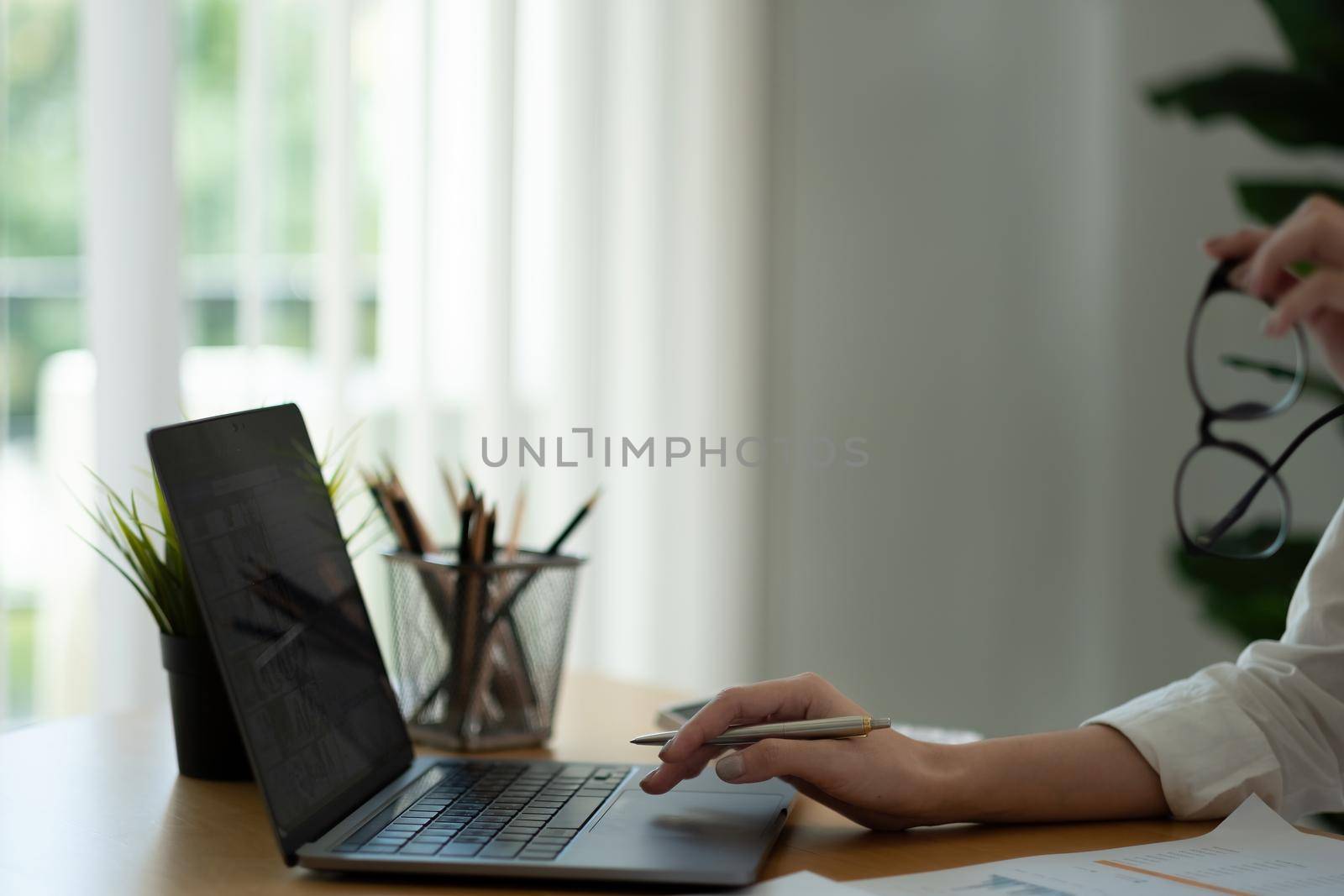 Businesswoman using laptop computer for analysis maketing plan, Accountant calculate financial report, computer with graph chart. Business, Finance and Accounting concept by nateemee