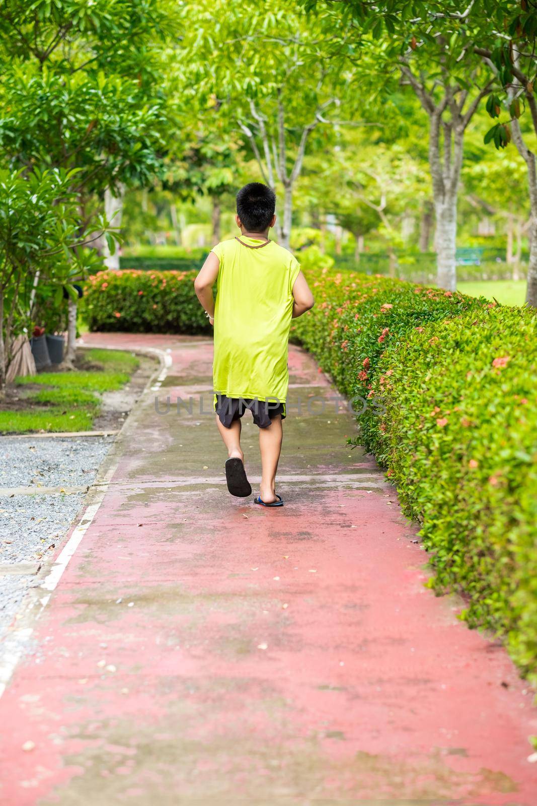 Rare view of young asian boy run in garden. by Benzoix
