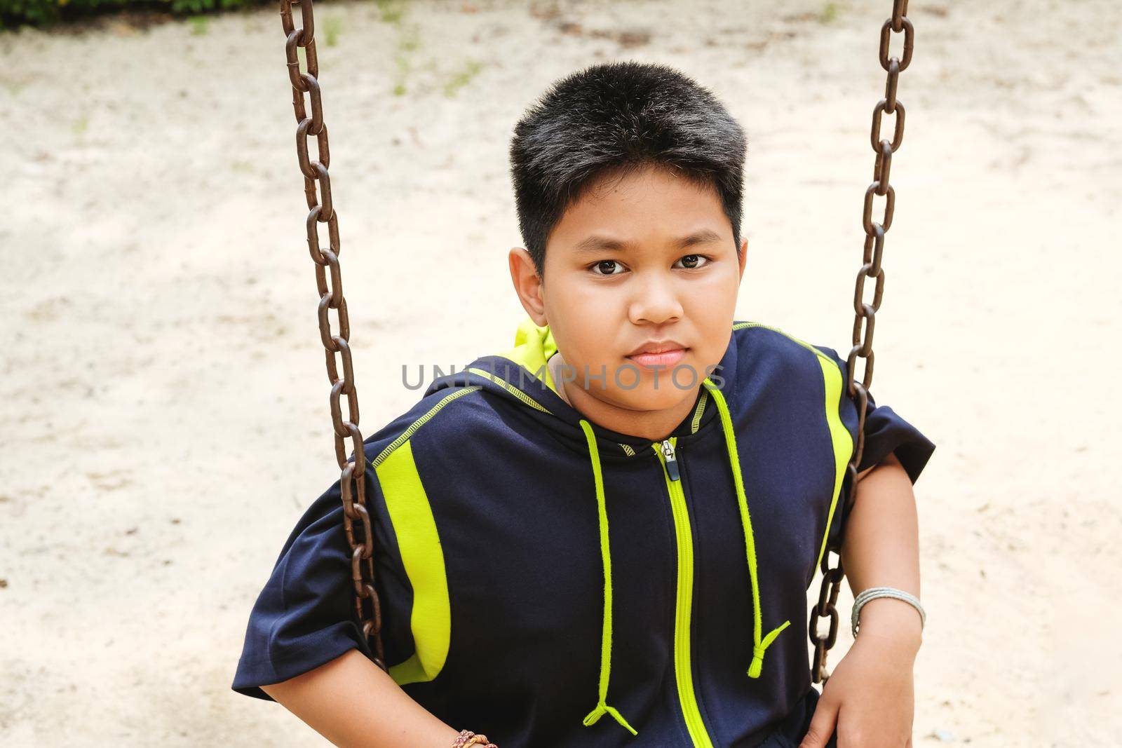 Happy asian sport boy play on swing playground in Garden. by Benzoix