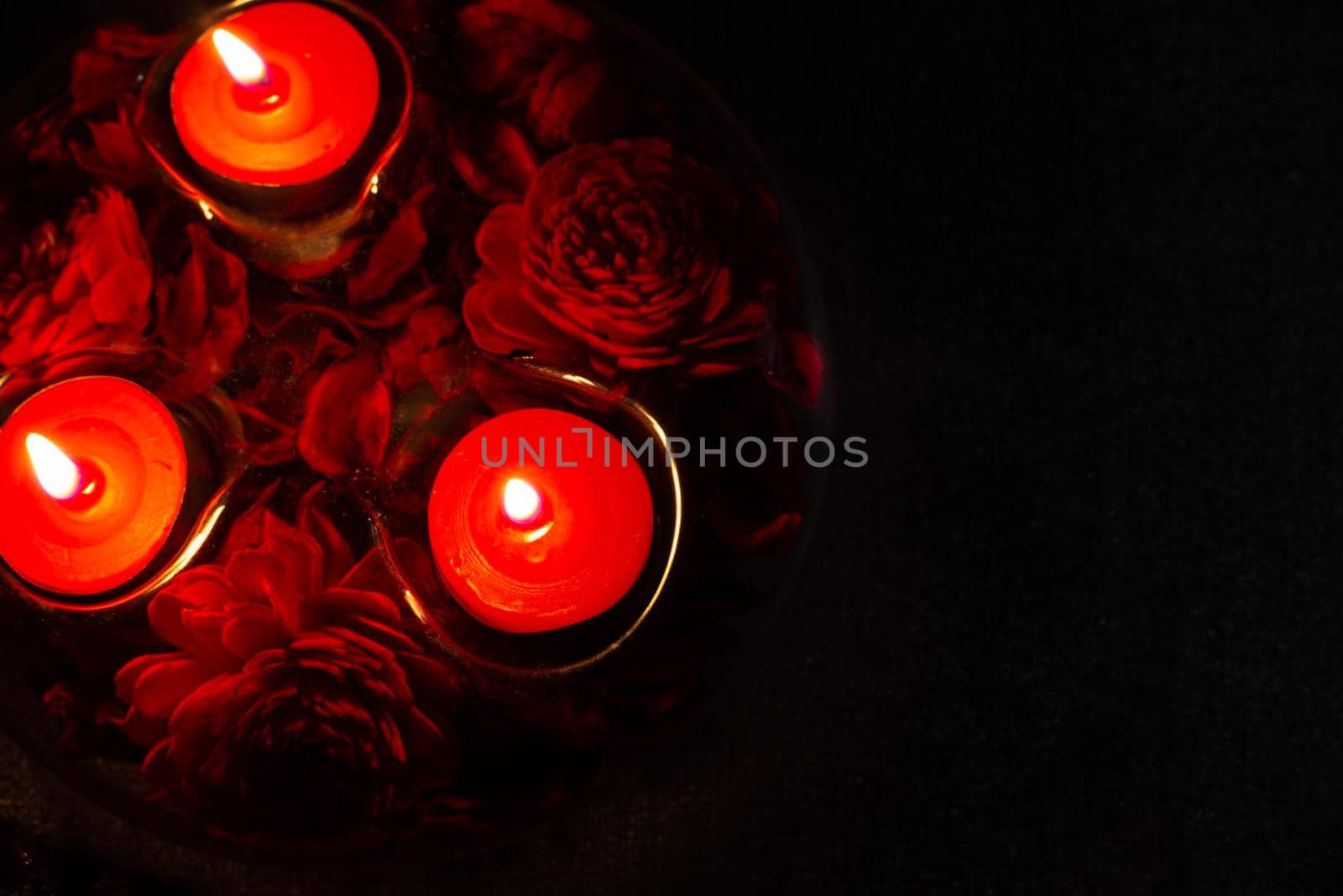 red candles in a candlestick on a black background, top view, with copy space