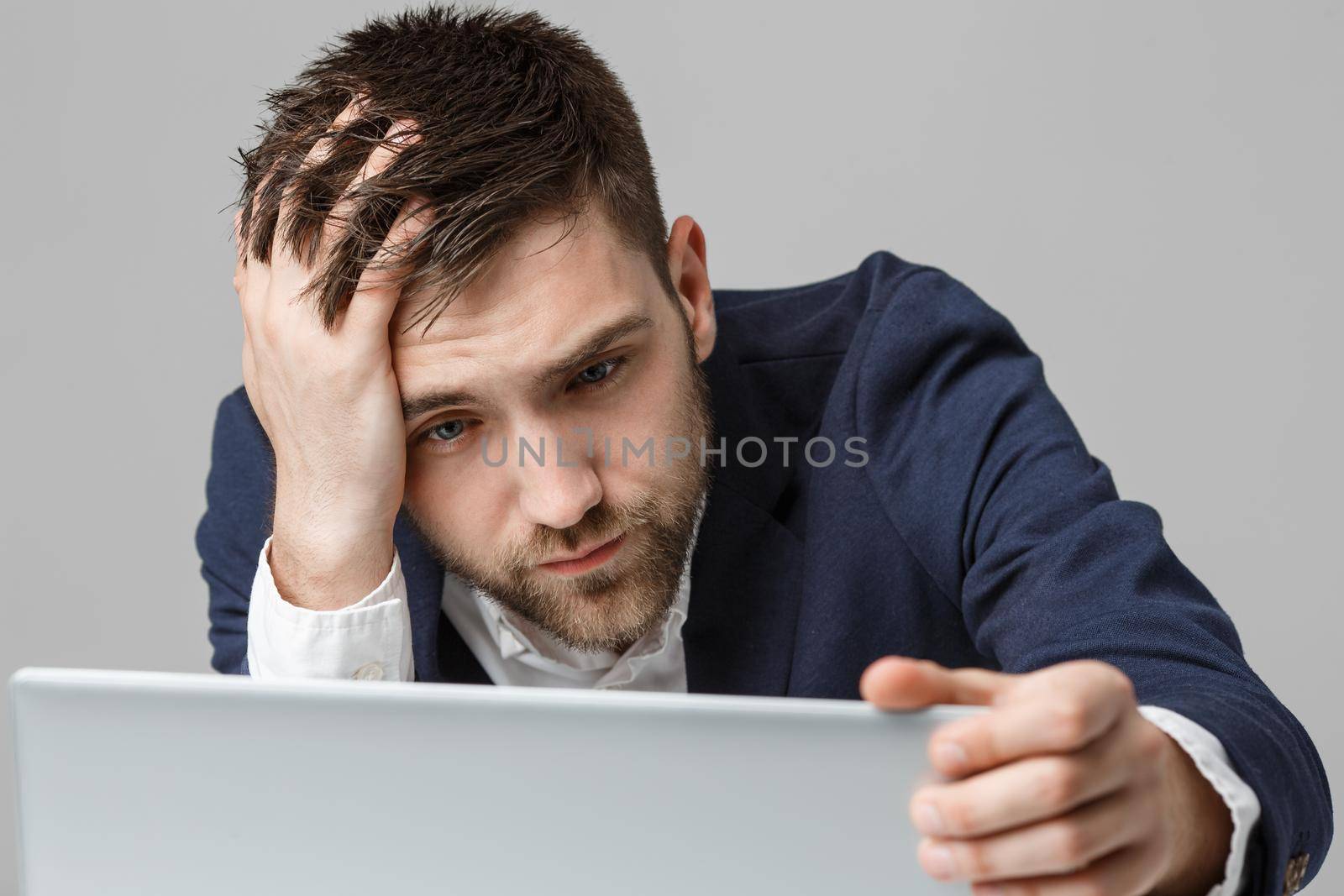 Business Concept - Portrait handsome stressful business man in suit shock looking at work in laptop. White Background. by Benzoix