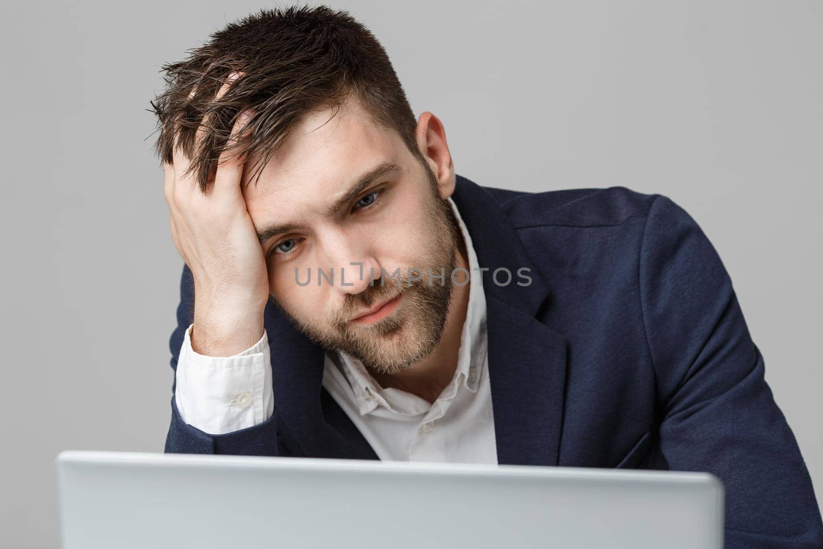 Business Concept - Portrait handsome serious business man in suit looking at laptop. White Background. by Benzoix