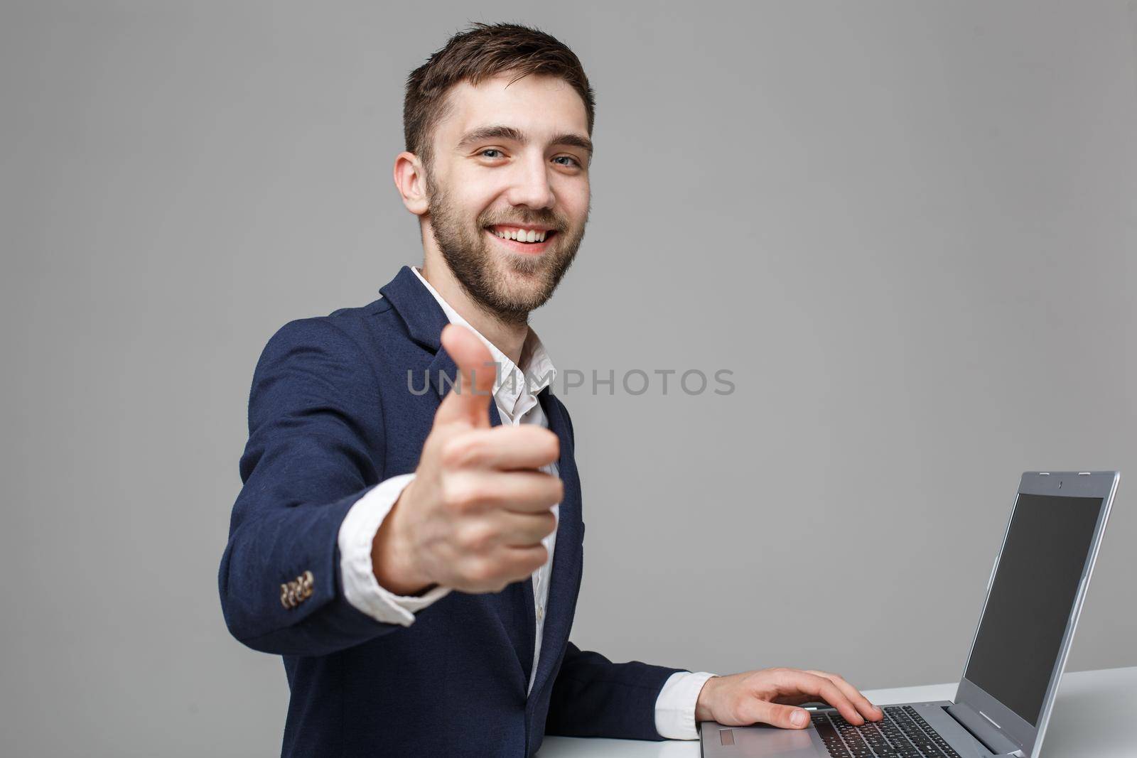 Business Concept - Portrait Handsome Business man showing thump up and smiling confident face in front of his laptop. White Background.Copy Space.