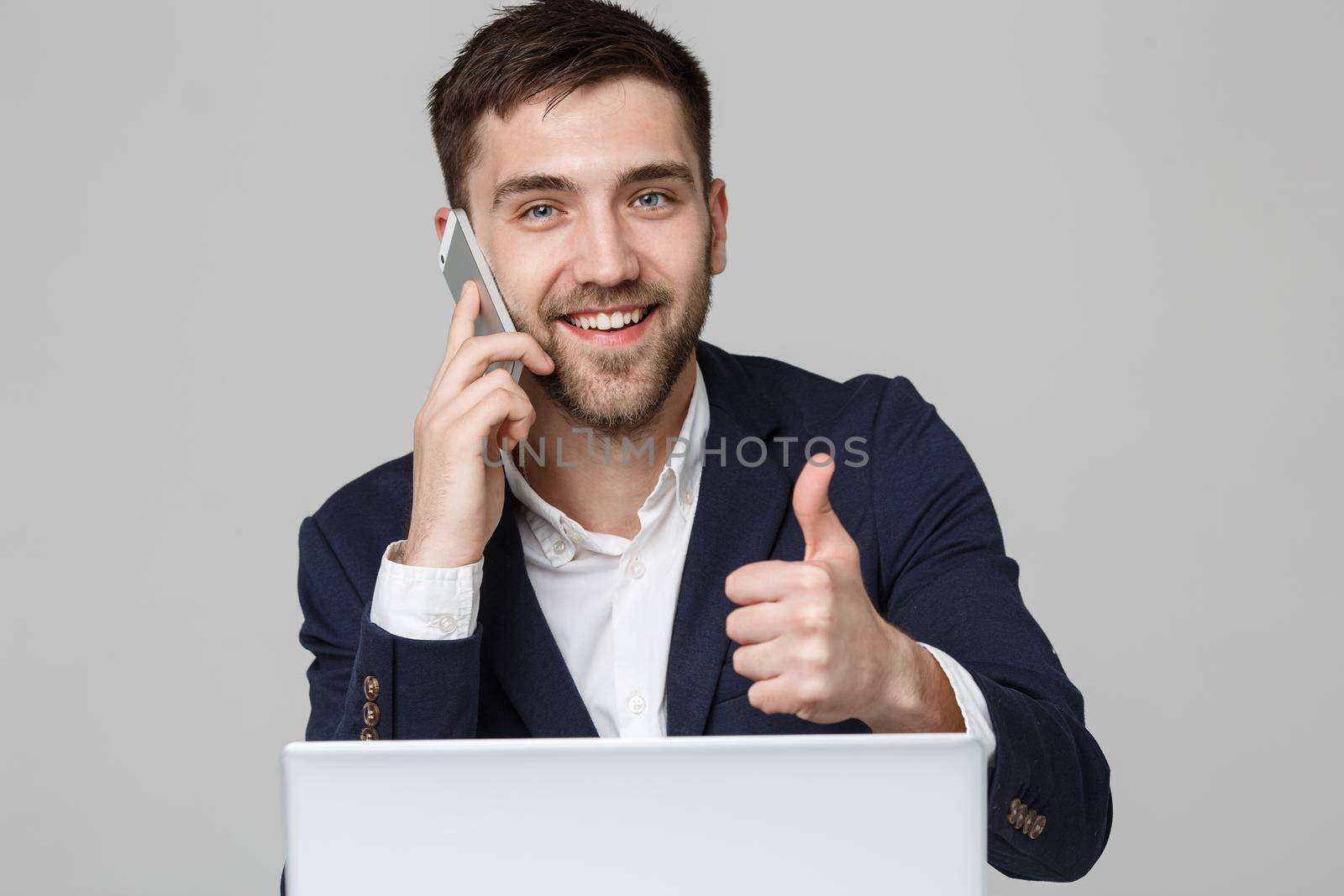 Business Concept - Portrait Handsome Business man showing thump up and smiling confident face in front of his laptop. White Background.Copy Space. by Benzoix