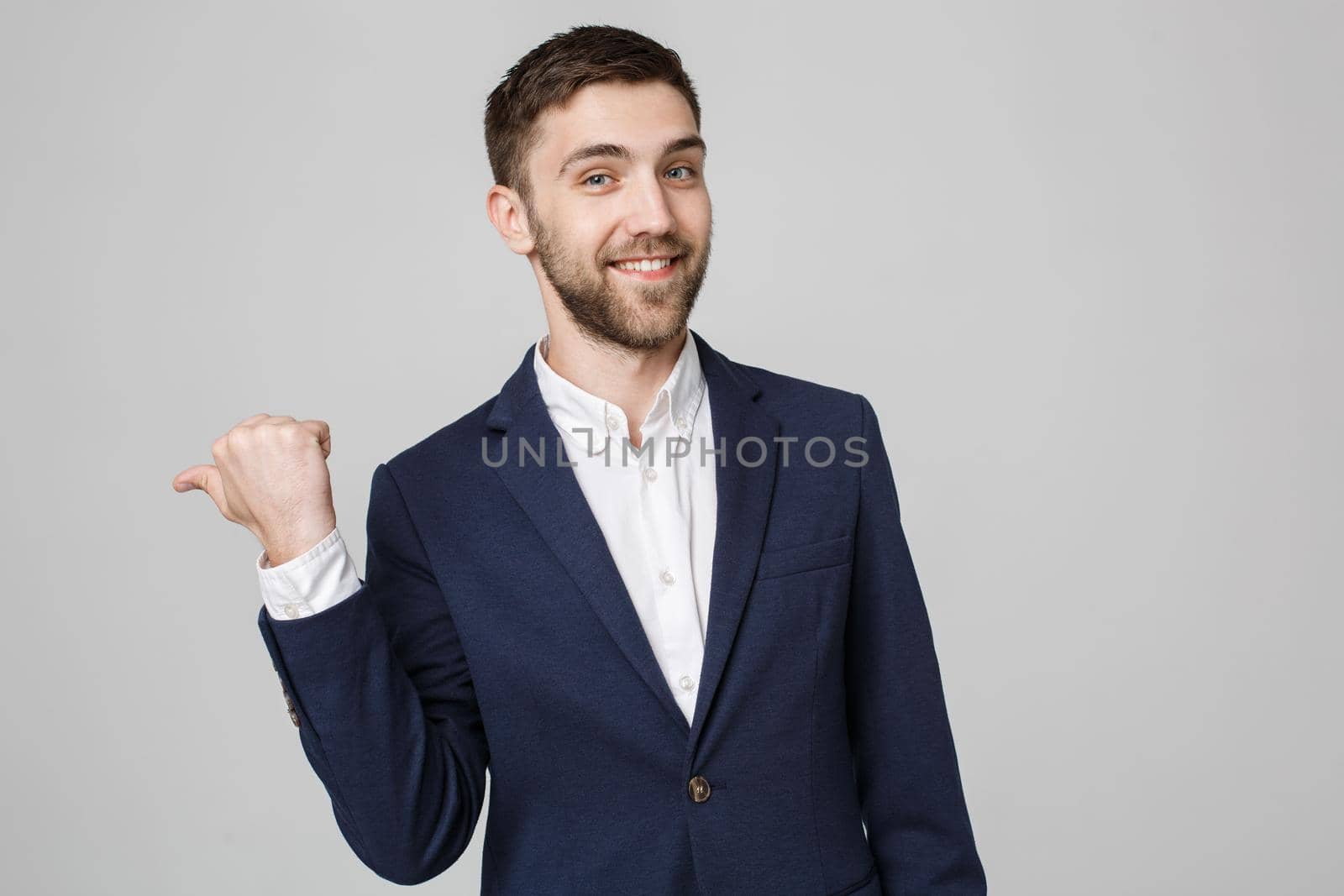 Business Concept - portrait young successful businessman pointing finger over dark background. Copy space. by Benzoix