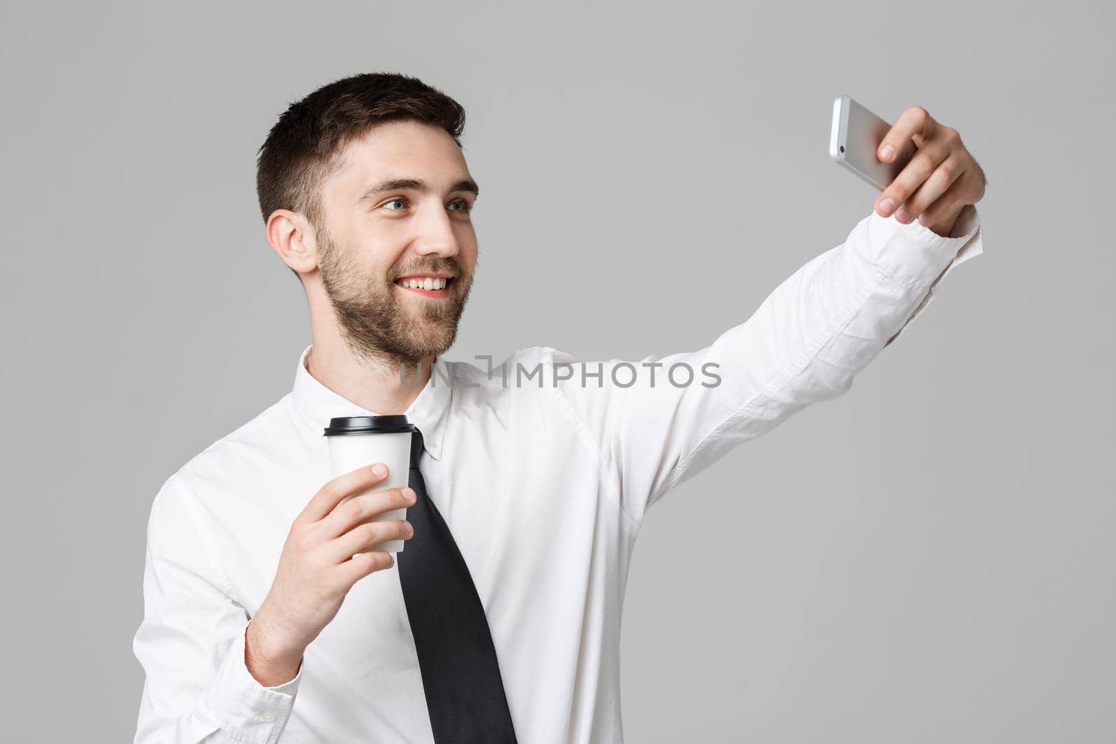 Lifestyle and Business Concept - Portrait of a handsome businessman enjoy taking a selfie with take away cup of coffee. Isolated White background. Copy Space.