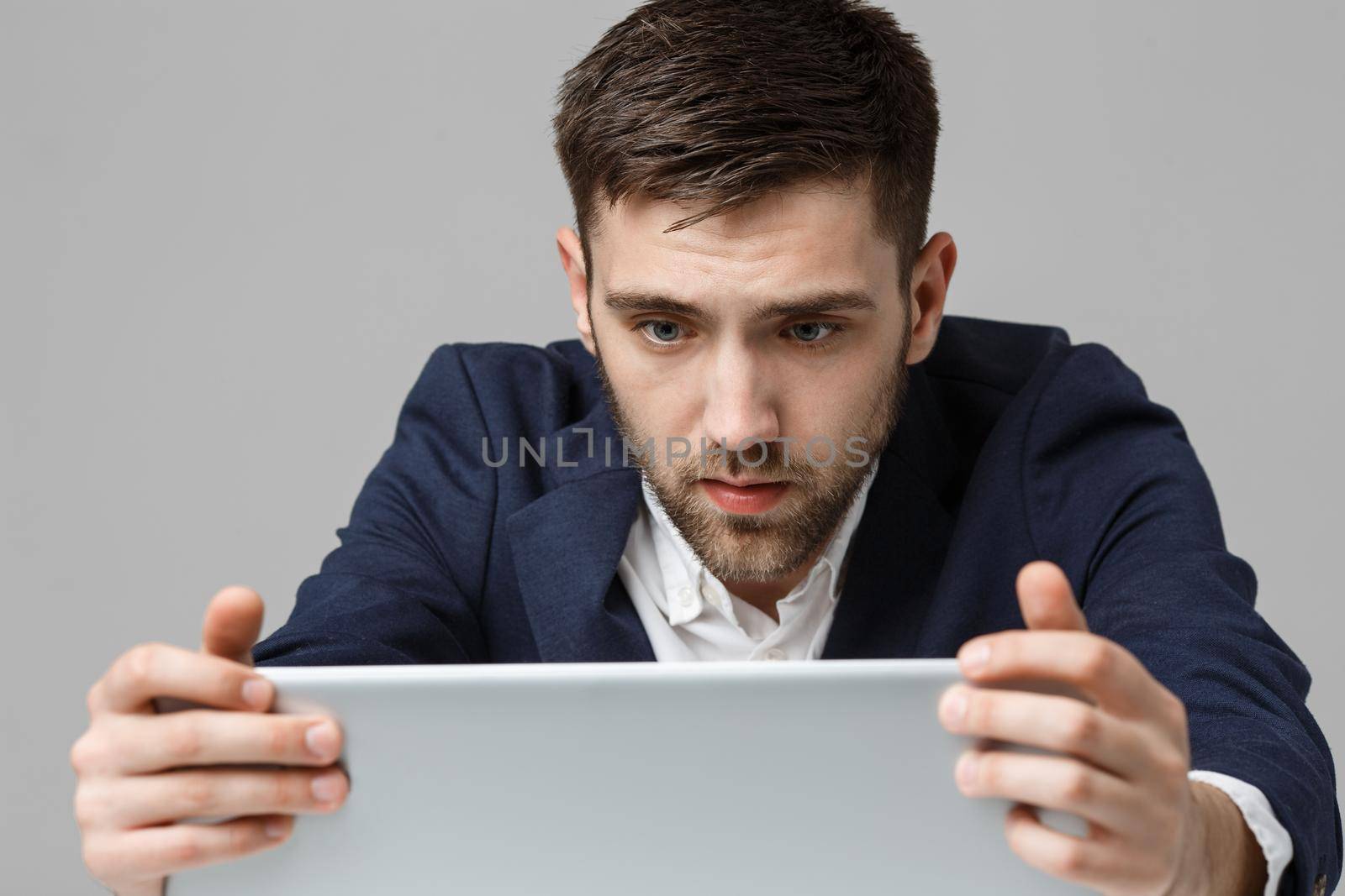 Business Concept - Portrait handsome stressful business man in suit shock looking at work in laptop. White Background. by Benzoix