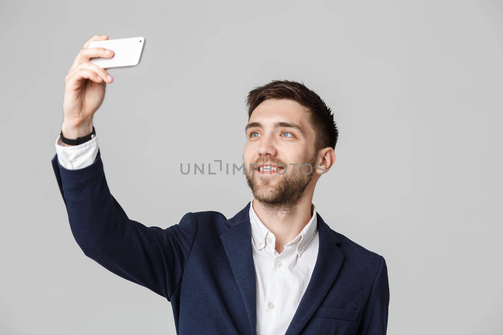 Business Concept - Handsome Business man take a selfie of himself with smartphone. White Background.