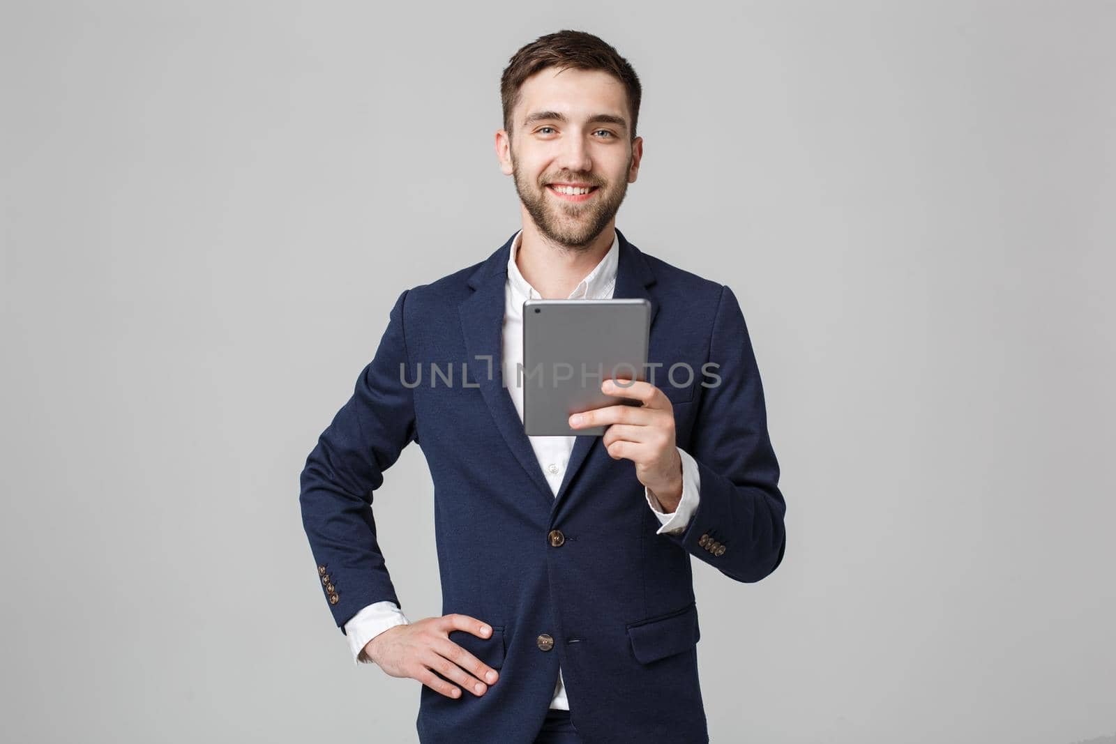 Business Concept - Portrait Handsome Business man playing digital tablet with smiling confident face. White Background. Copy Space. by Benzoix