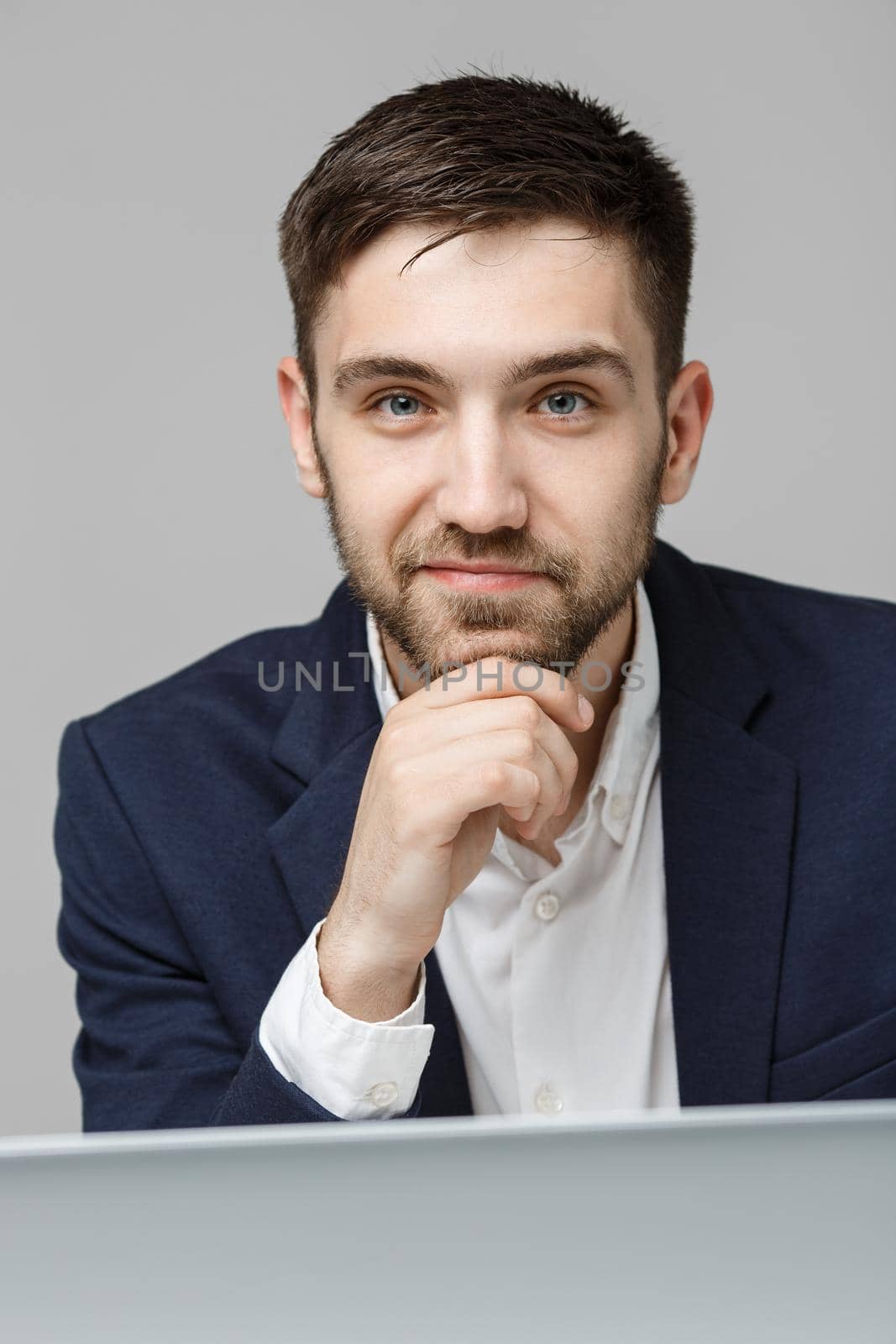 Business Concept - Portrait handsome serious business man in suit looking at work in laptop. White Background.