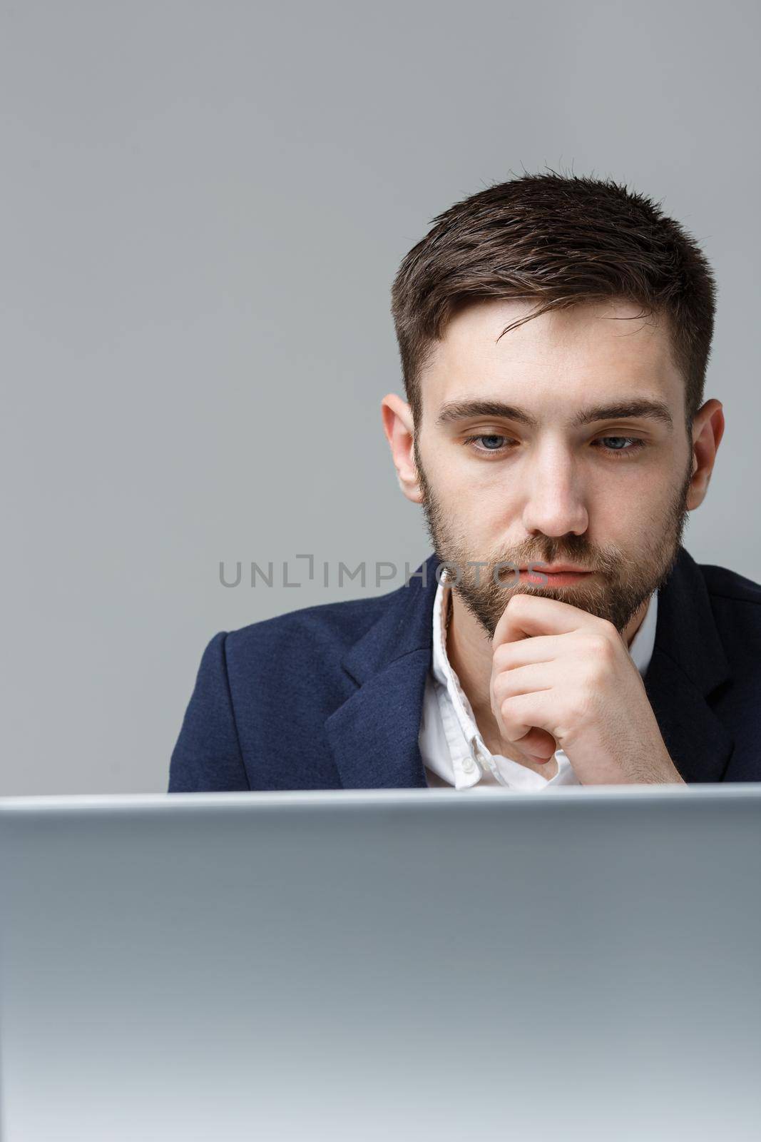 Business Concept - Portrait handsome stressful business man in suit shock looking at work in laptop. White Background.