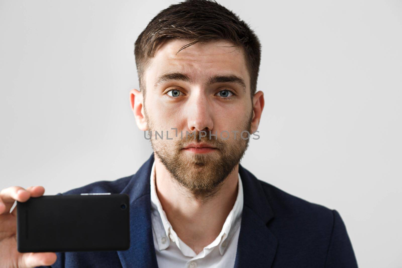 Business Concept - Handsome Business man take a selfie of himself with smartphone. White Background.