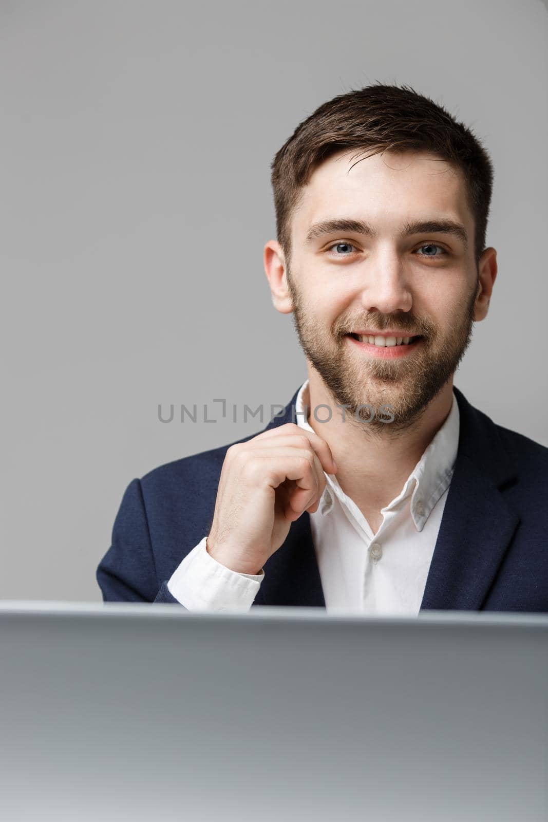 Business Concept - Portrait handsome happy handsome business man in suit smiling and siting in work office. White Background.