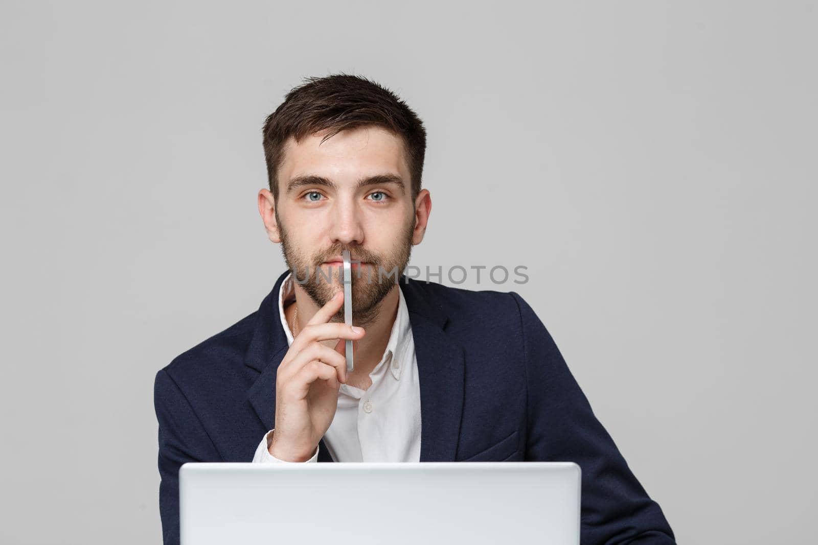 Business Concept - Portrait handsome happy handsome business man in suit playing moblie phone and smiling with laptop at work office. White Background. by Benzoix